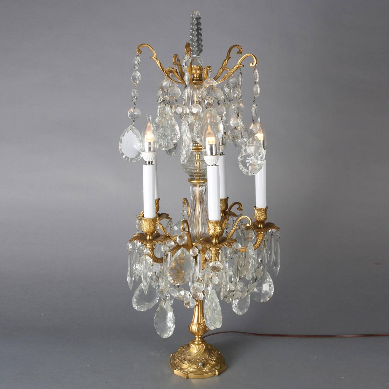 Pair of antique Italian gilt bronze and crystal electrified candelabra lamps features foliate form arms terminating in five candle lights, upper tier also with foliate arms, all-over hanging cut crystal prisms, newly rewired, circa