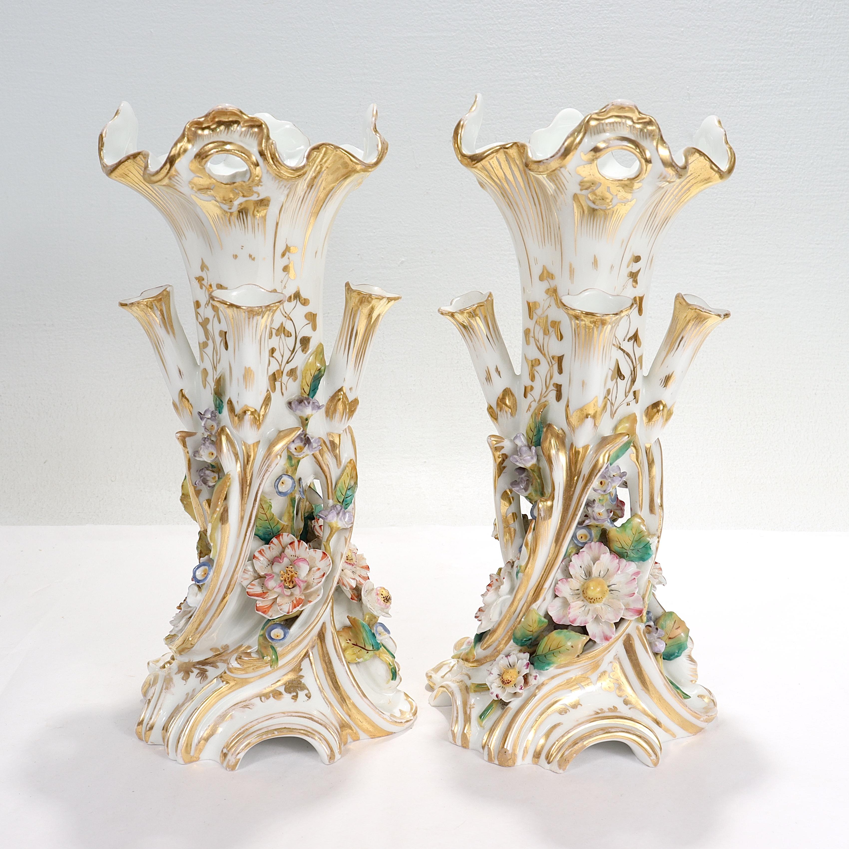 A fine pair of antique porcelain flower vases.

In the style of Jacob Petit.

Each with a large central vase surrounded by 4 smaller, integral bud vases.

With extensive gilding and floral decoration throughout.

Simply a great pair of antique