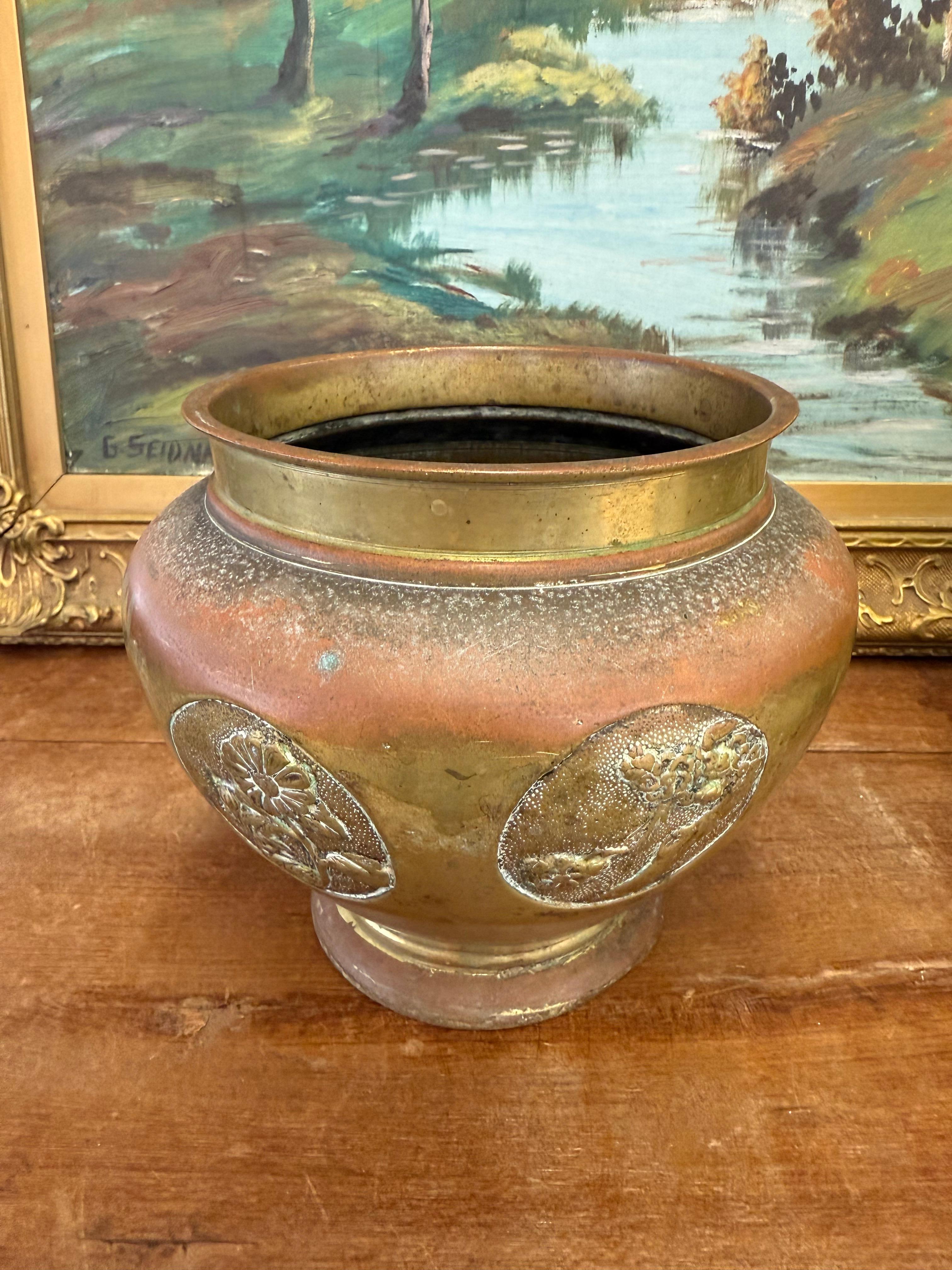 Rappelant la Jardinière, cette paire de jardinières en laiton antique présente des motifs floraux et botaniques gaufrés, apportant un charme d'antan à tout espace. Avec une patine vieillie et chaleureuse, ces vases décoratifs s'intègrent