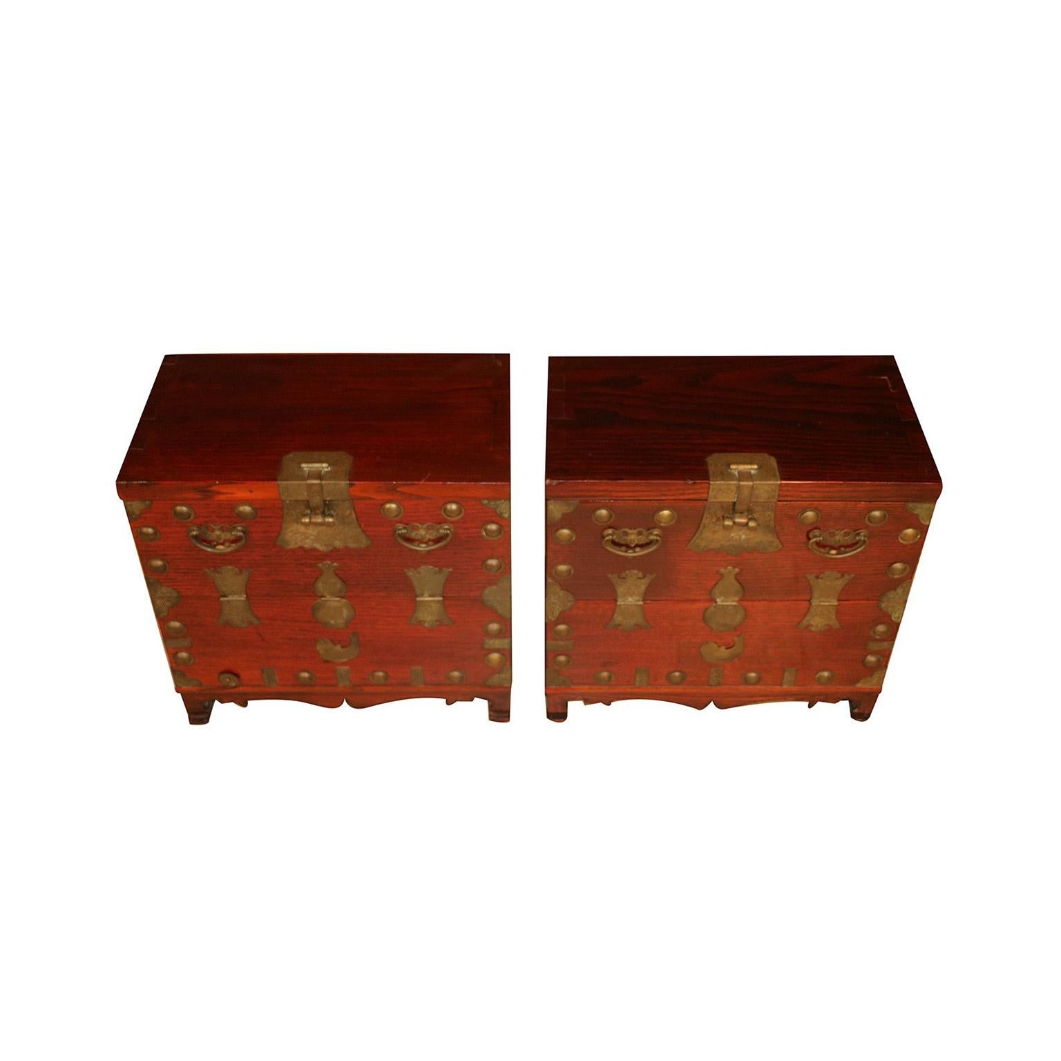 A remarkable pair of antique Korean elm small chests, with original brass hardware, circa late 19th century. Featuring richly grained wood, beautifully engraved brass hardware and lovely adornments. Framed by brass corner accents and round, studded