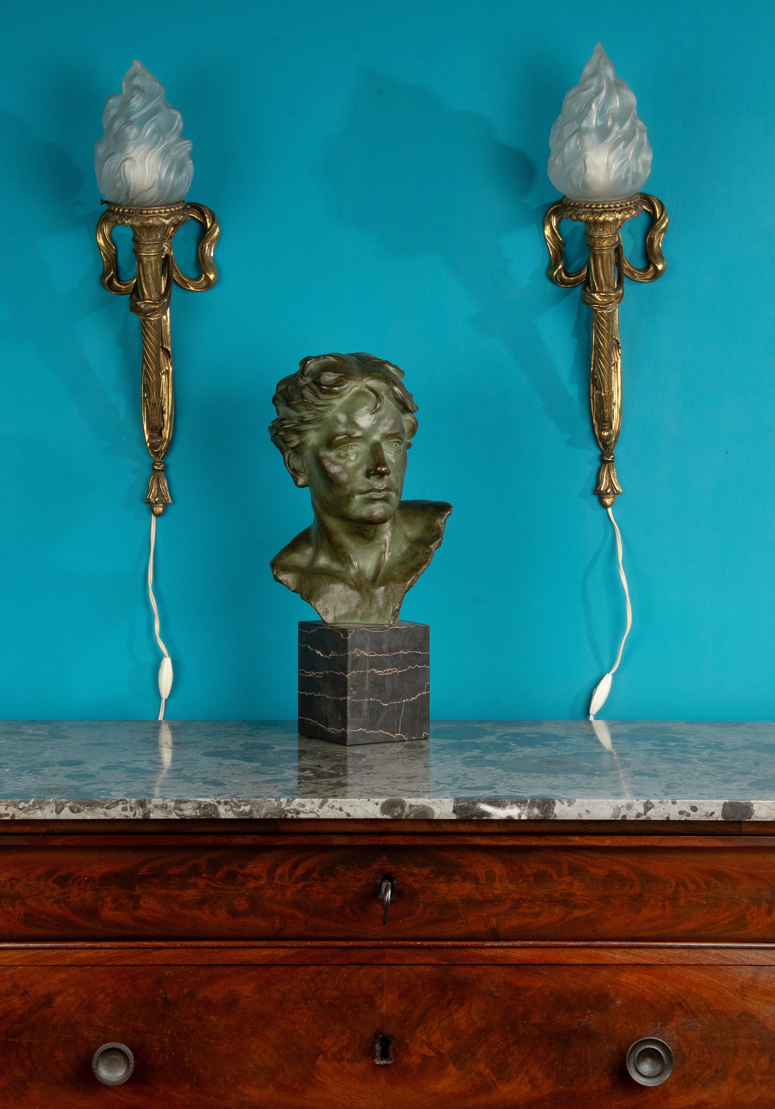 Ein Paar antike große Wandleuchter / Leuchten, aus kaltvergoldeter Bronze. Die fackelförmigen Lampen haben Lampenschirme aus satiniertem Glas in Form von Feuerfackeln. Verziert mit typischen Louis XVI-Elementen, Band und Schleife, drapierter