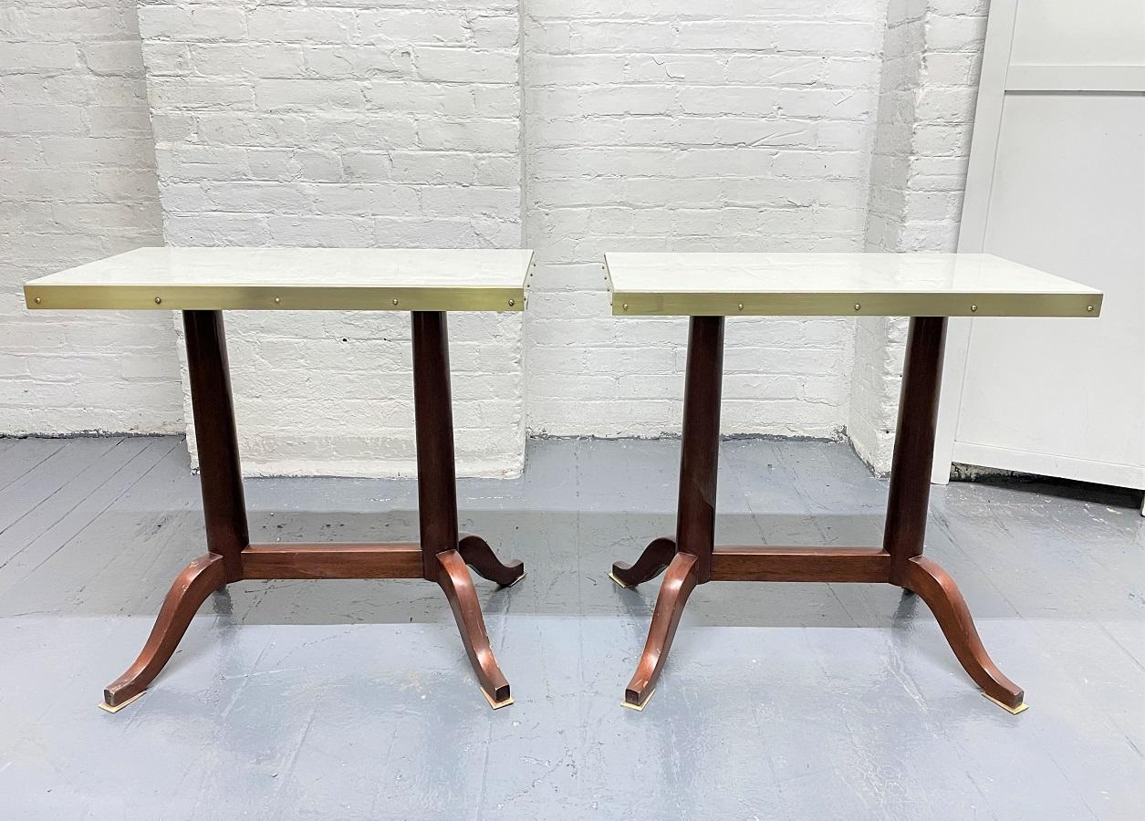 Pair of antique mahogany and marble top side tables. The tables have marble inserts with bronze trim and bronze padded feet. The frame is solid mahogany.