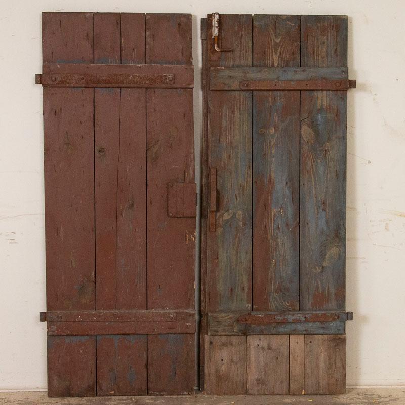 This pair of original brown painted doors have the weathered, aged appeal that create a unique focal point as interior sliding doors in today's modern home. Notice the upper panels have diagonal planks while the lower section has vertical planks of