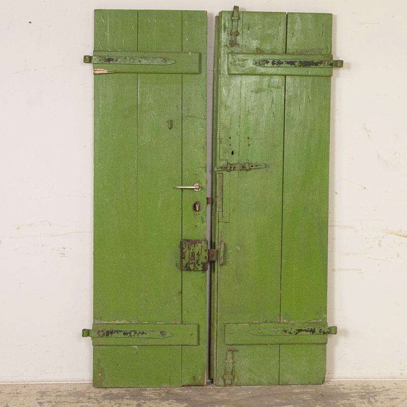 Antique doors make a style statement as interior sliding doors in today's modern home. This pair of original painted green doors will add a vibrant, fun touch to your interior. Notice the intriguing pattern of wood slats in these 6' tall doors, and