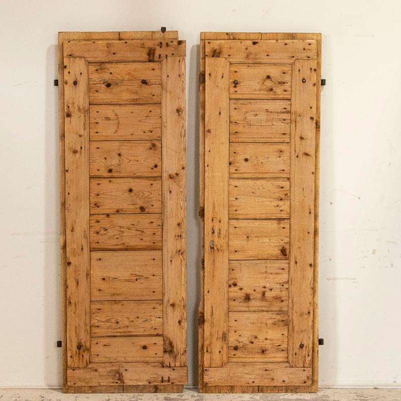 Using old barn doors as interior sliding doors is a great way to add character and a personal touch to your home. This pair of barn doors has a unique look reminiscent of shutters, and the original wrought iron detail adds to their genuine vintage
