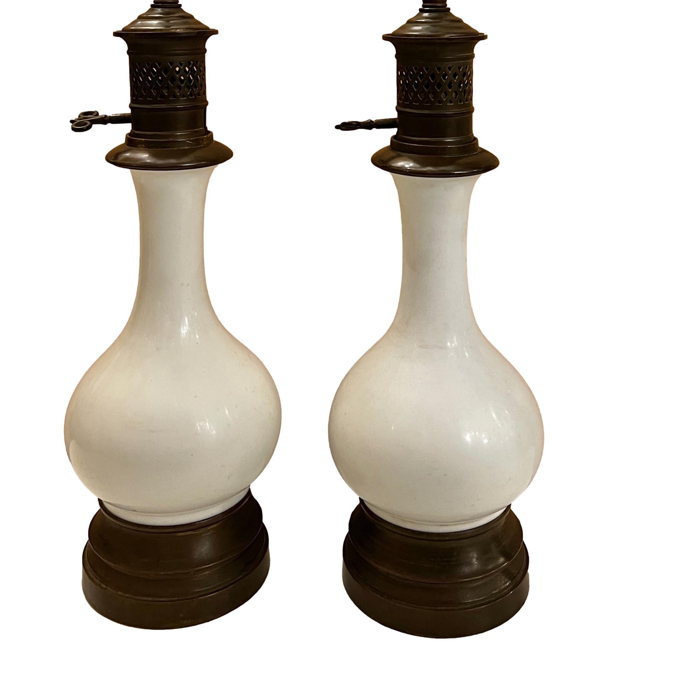 A pair of circa 1920’s French white porcelain table lamps with original patina.

Measurements:
Height of body: 15?
Height to shade rest: 24?
Diameter at widest: 5.5?.
