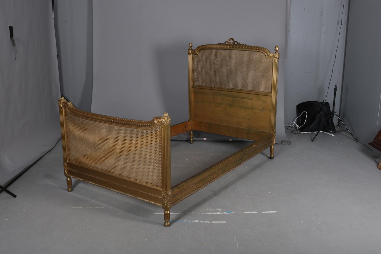 A pair of RJ Horner twin bed feature French Louis XIV styling with giltwood and caned frames having bow tied and foliate crest, reeded columns with rosettes at the capitals surmounted by acanthus finials, and raised on turned and reeded legs