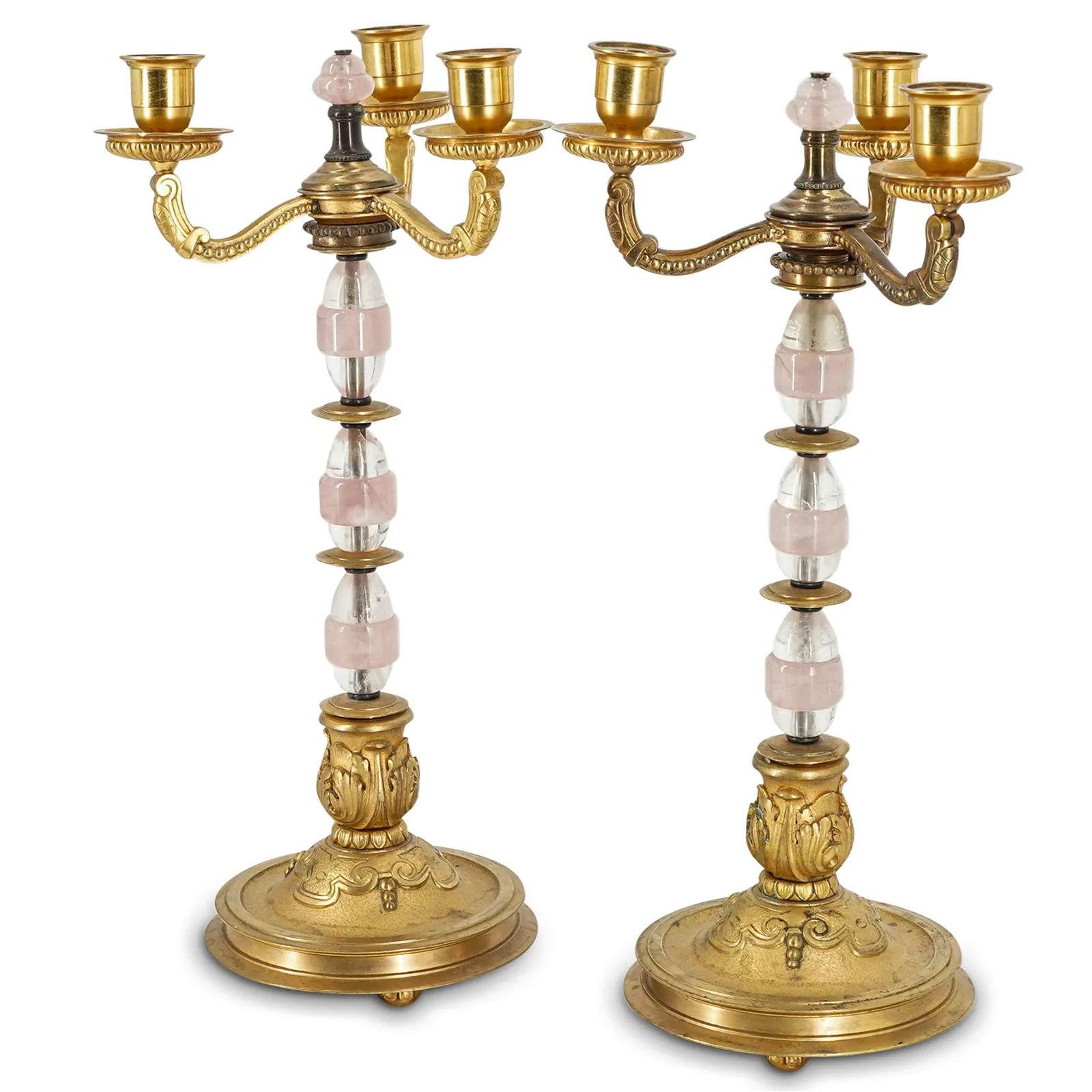 Our beautiful pair of antique gilt bronze candelabra feature standards comprised of ovoid shaped rock crystal with rose quartz bands set upon round pedestals with ball feet, and three candle arms. Apparently unsigned. Likely of northern European