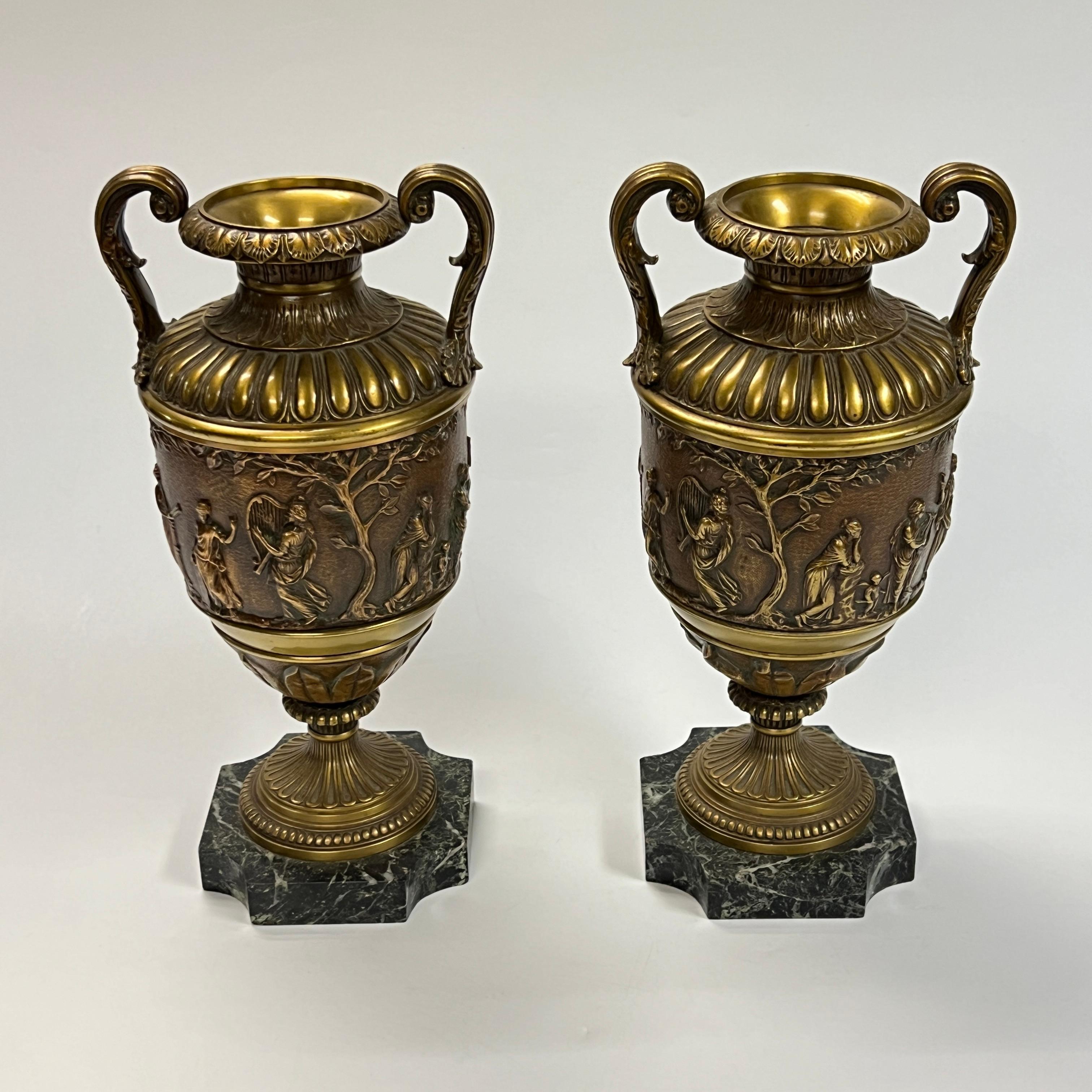 Paire de vases anciens en bronze patiné avec piédestaux en marbre vert panaché, de style néoclassique romain, avec des figures finement moulées de musiciens et de muses en procession sur le corps de chaque vase.  