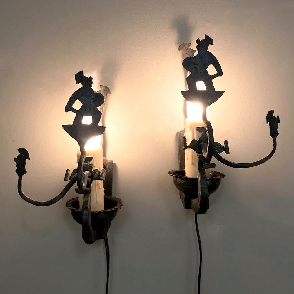 Pair of antique rustic wrought iron wall sconces are perfect for adding a rustic, Old World ambiance to your lighting scheme. The martial theme of armored combatants creates a masculine effect, with the figures shading the direct glow of the lamp