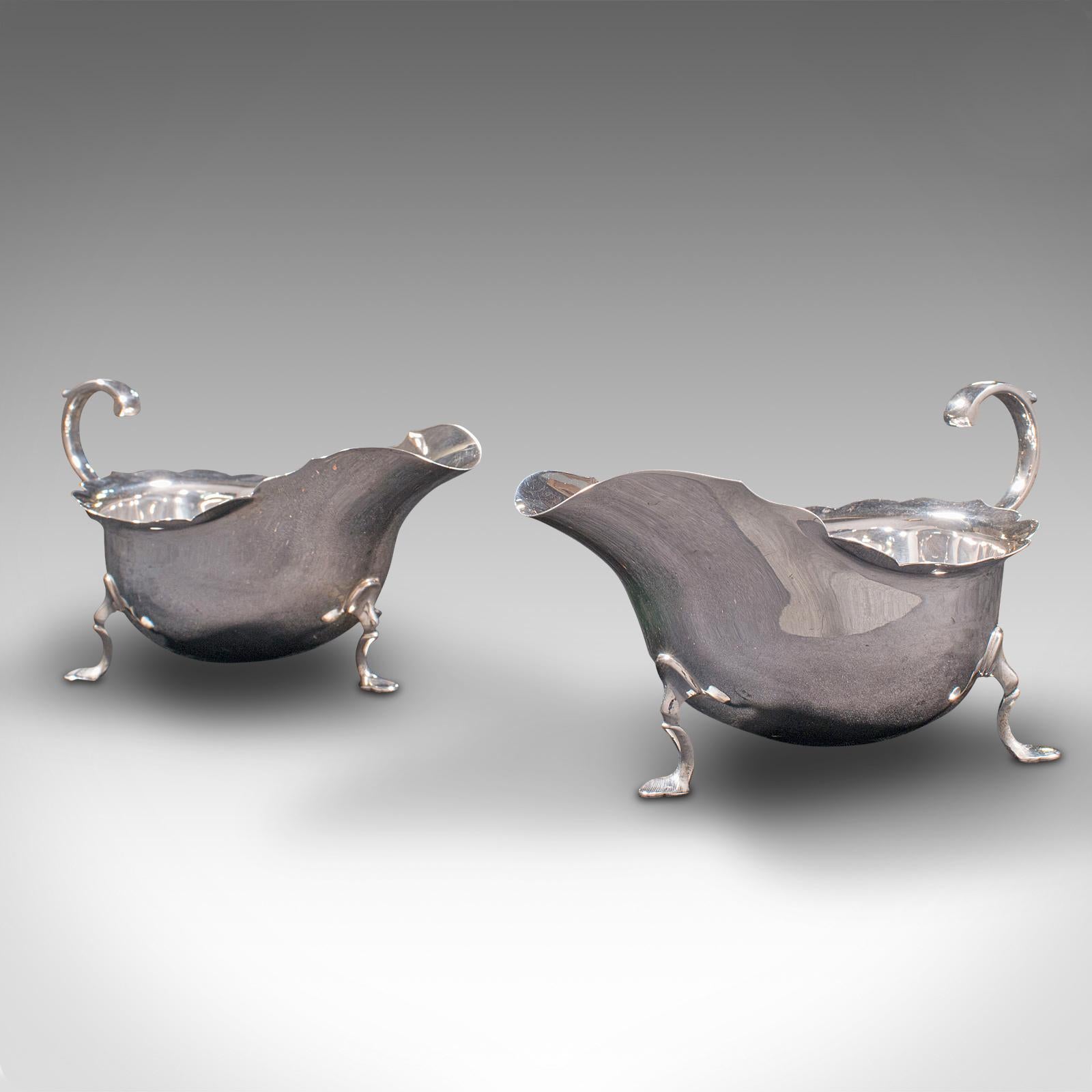 This is a pair of antique sauce boats. A British, silver condiment dish with serving spoons, hallmarked during the Edwardian period, 1909.

Delightfully presented, ready for the dining table
Displays a desirable aged patina throughout
Quality