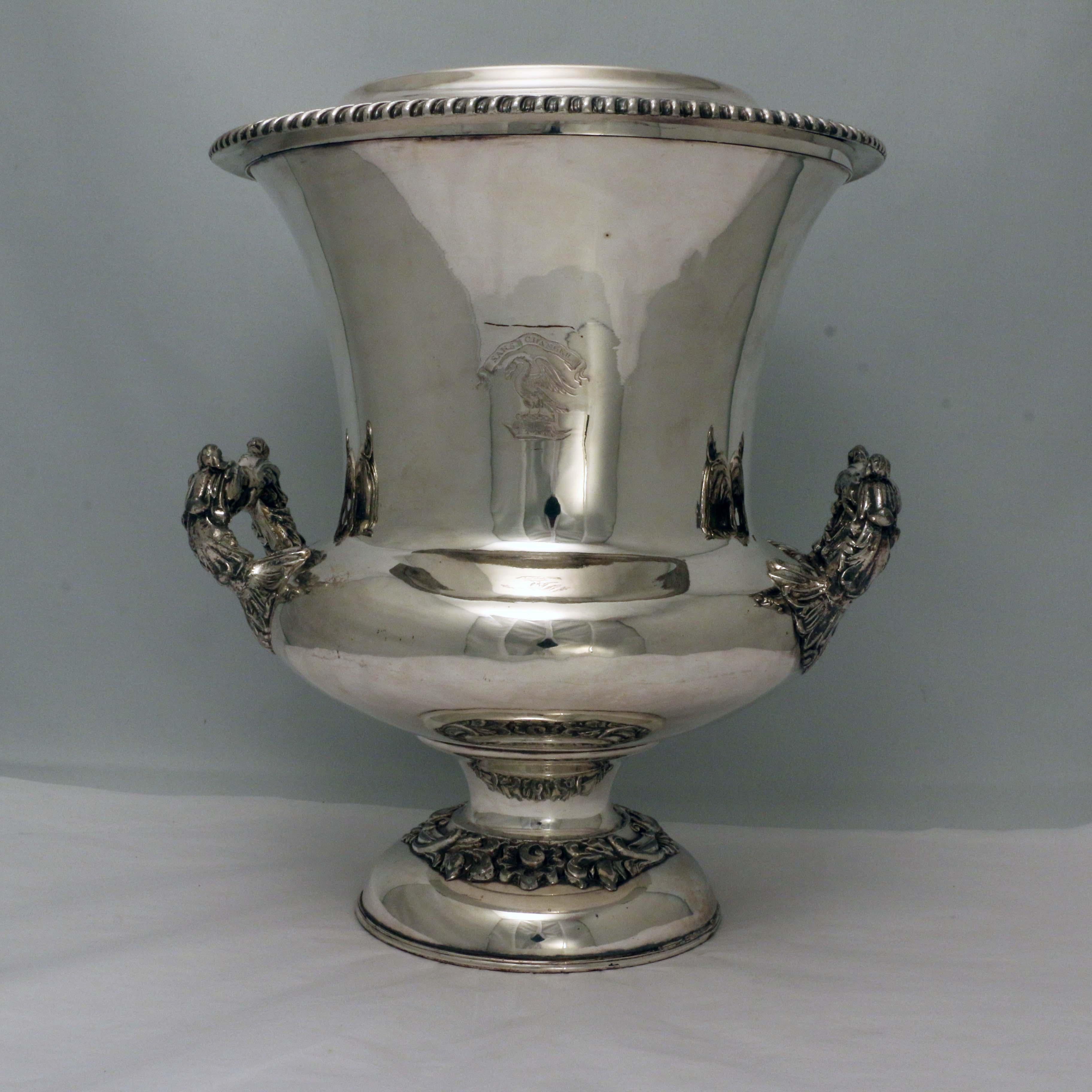 A very hansome pair of Antique Georgian Old Sheffield silver plated wine coolers in the Campana style, with applied garoon borders, two side-handles with anthemion leaf mounts, with original interiors and covers, and all sitting on pedestal feet.