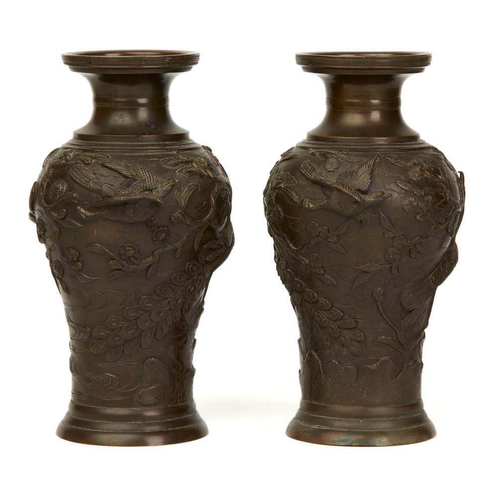 A very fine pair antique Japanese bronze vases moulded in relief with a continuous landscape with two exotic wading birds, one male the other female meeting each other while another bird flies off. The casting quality is excellent and both vases