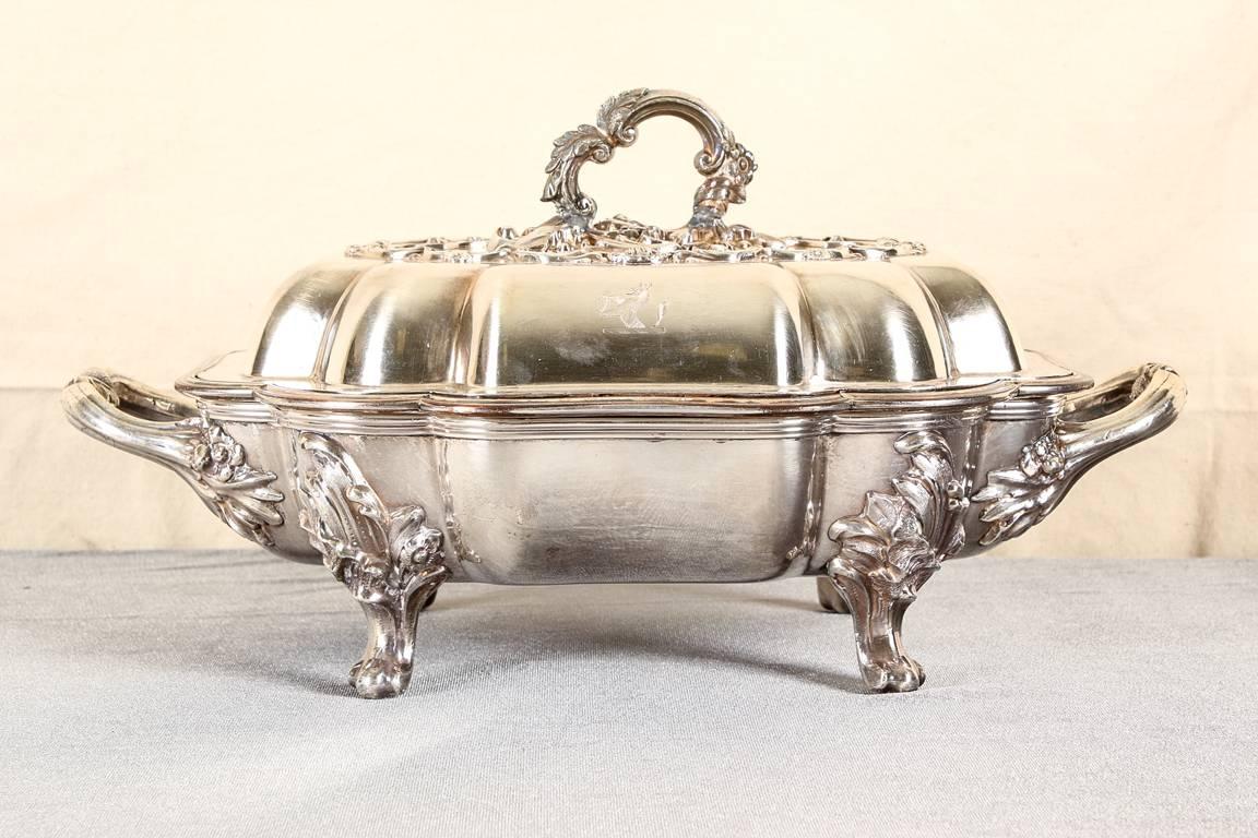 Pair of antique silver plate lidded serving dishes, Georgian style lobed twin-handled dishes with lift out trays, the lid with raised acanthus scrolls and shell motifs, handles with raised floral mounts, and raised on acanthus scrolled feet.