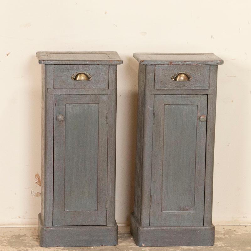 Finding a matched pair of petite nightstands can be a Challenge, making this pair a special find for someone needing to furnish a small scale bedroom. The original gray painted finish shows age-related distress while the drawers and doors function