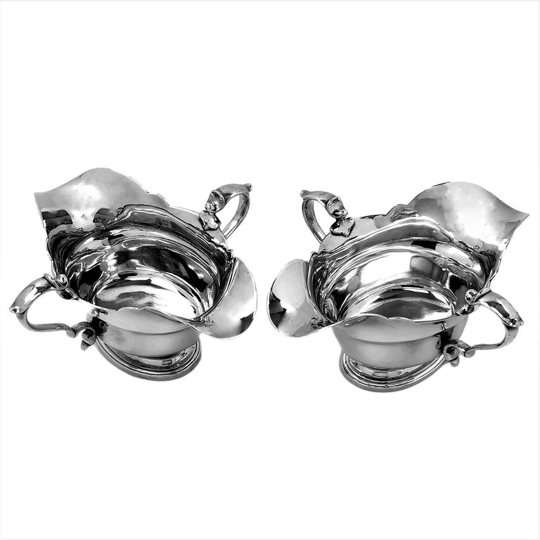 A pair of elegant Antique solid Silver Sauce Boats / Gravy Jugs each with a pair of everted spouts. The understated Gravy Boats are made in the style of early 18th century George I Sauce Boats from c. 1720. These Sauce Boats have a good
