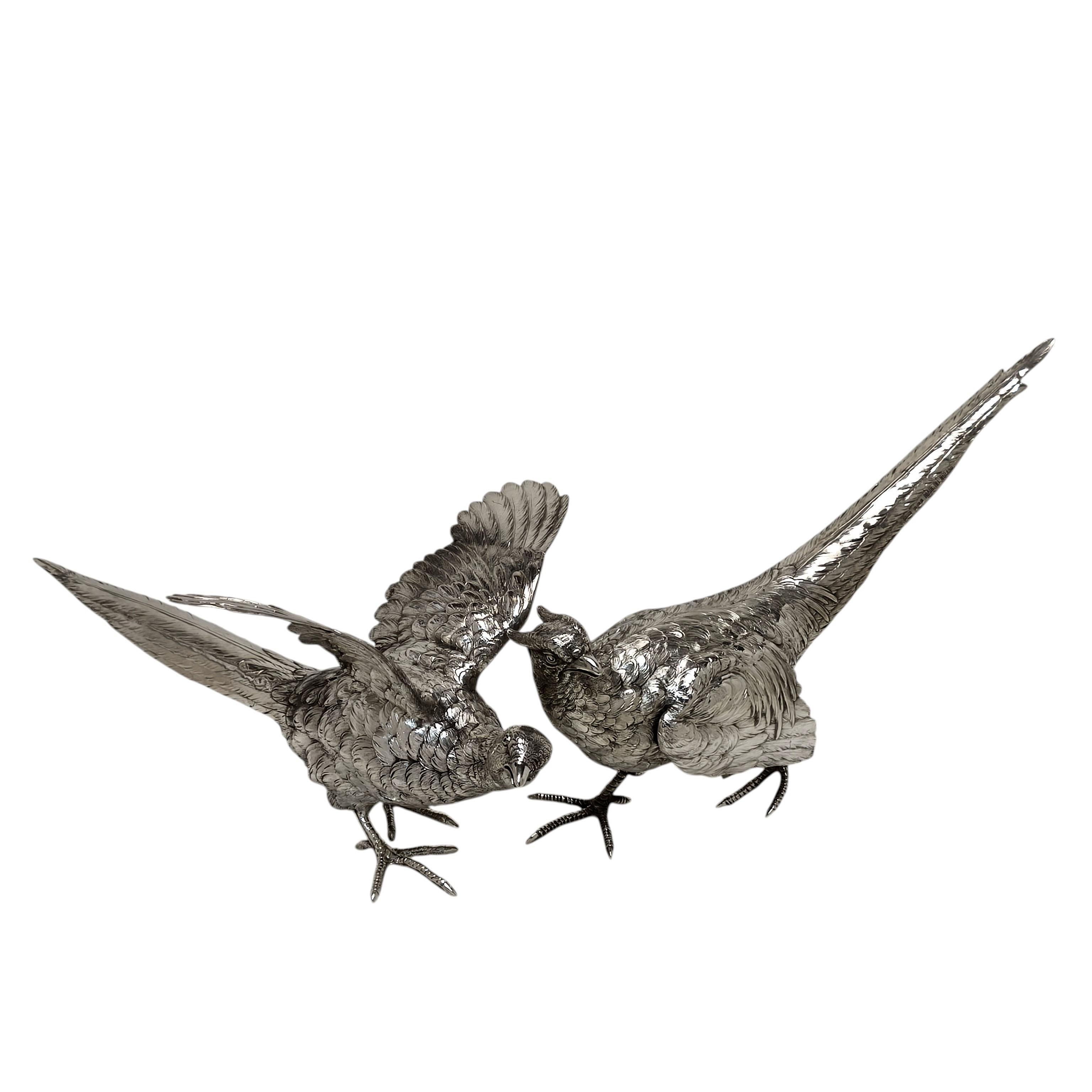 Une paire de faisans anciens en argent massif, modelés avec un grand souci du détail. L'ensemble comprend un faisan coq et un faisan poule avec des ailes évasées.

Fabriqué en Allemagne avec des marques d'importation anglaises pour 1921 et fabriqué
