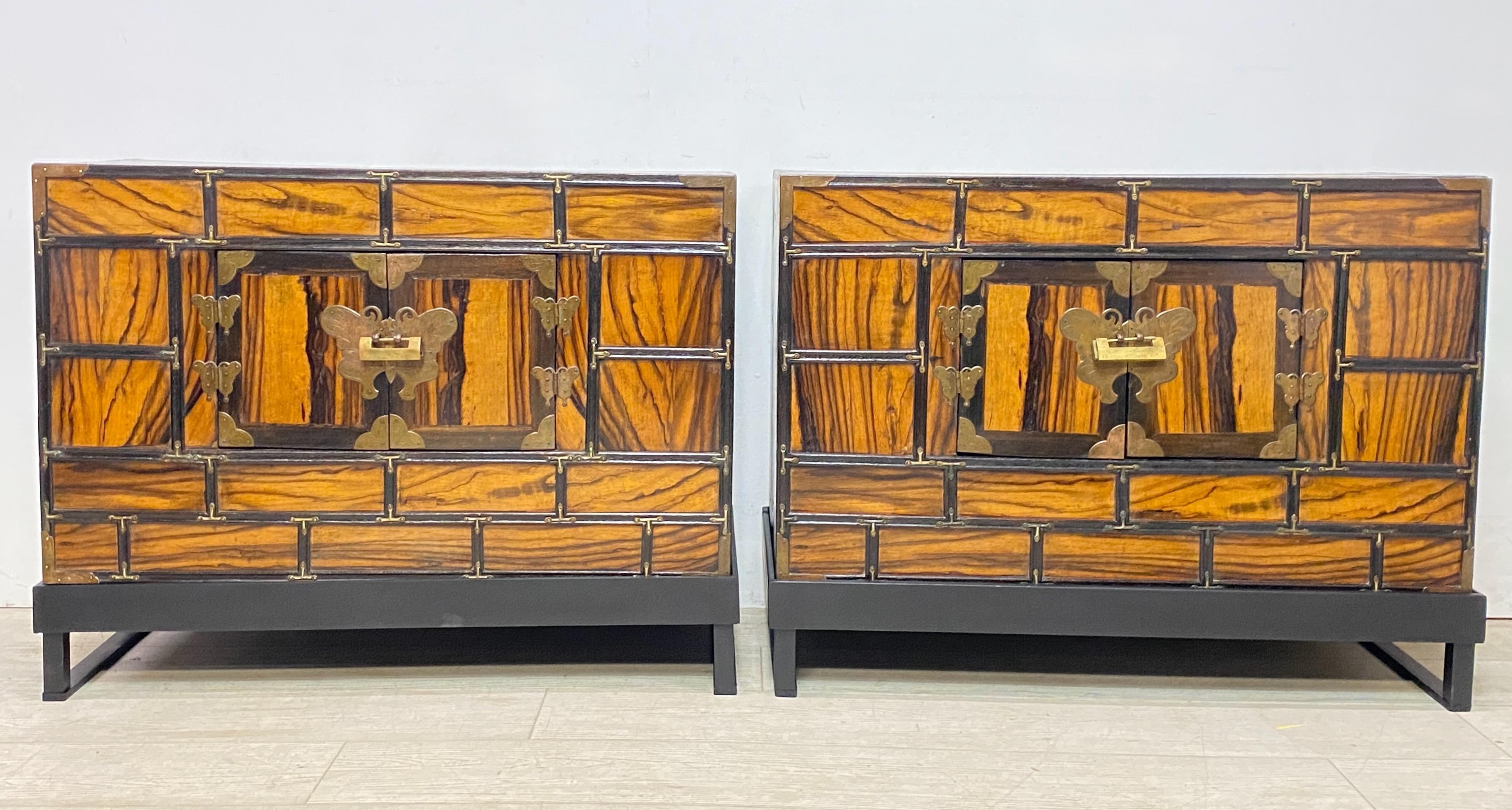 A pair of unusual Persimmon wood veneer over Pine bedside cabinets / tables on recent custom made bases. Original paper lined interior with sold brass hardware and fittings. 
Early 20th century (possibly older).
Thailand
Clean and in very good