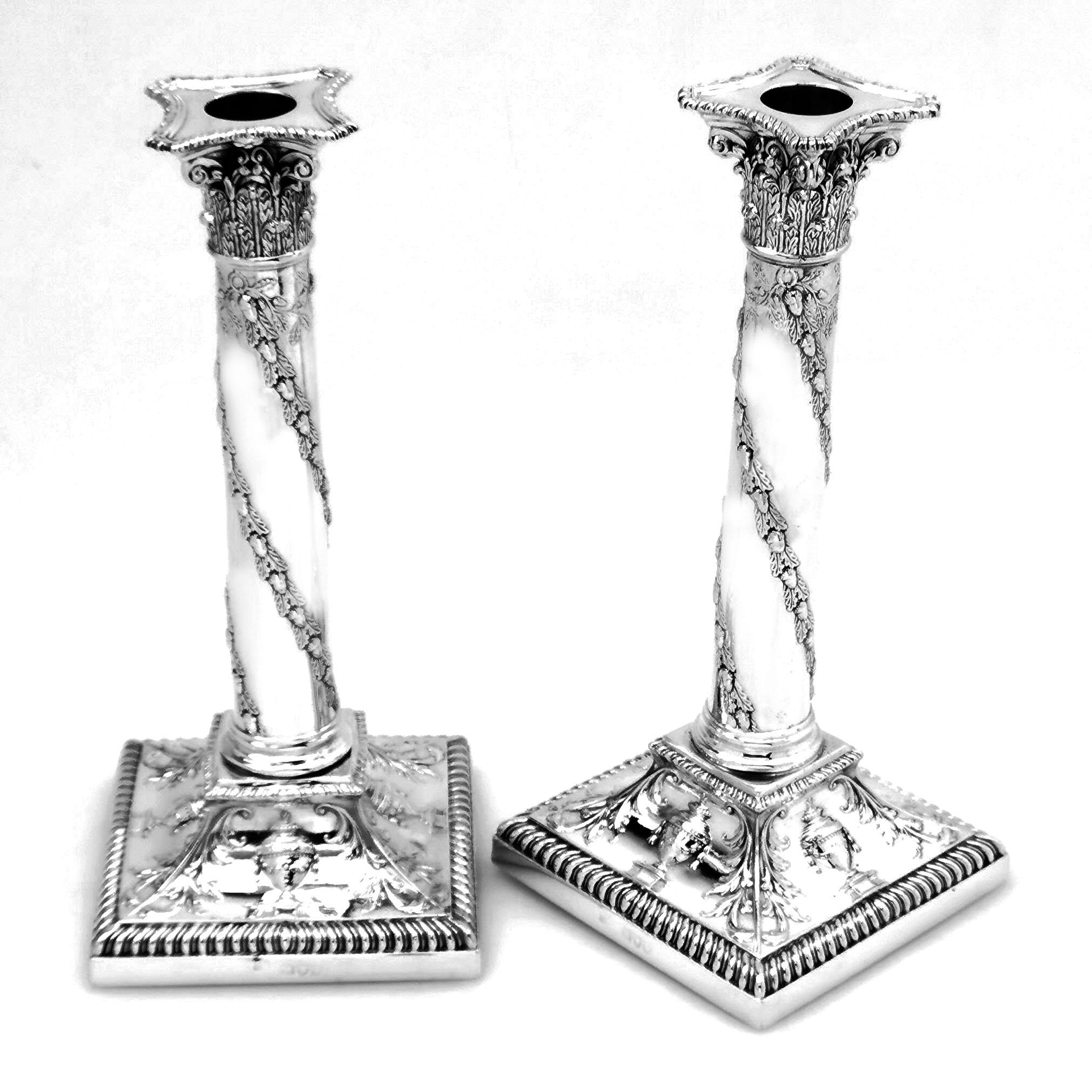 A lovely set of Antique Victorian sterling Silver Candlesticks with traditional Corinthian column capitals and chased vine leaf designs wrapping around the column. The square base of the Candlesticks is decorated with chased designs showing