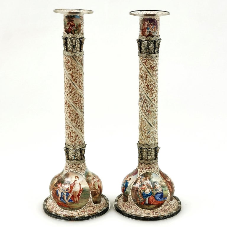 A lovely pair of Antique Viennese Enamel on Silver Candlesticks. These Candlesticks feature intricate Viennese Enamel designs on the entire exterior surface, on the underside on the candlesticks and on the top in the capital. The base of each of the