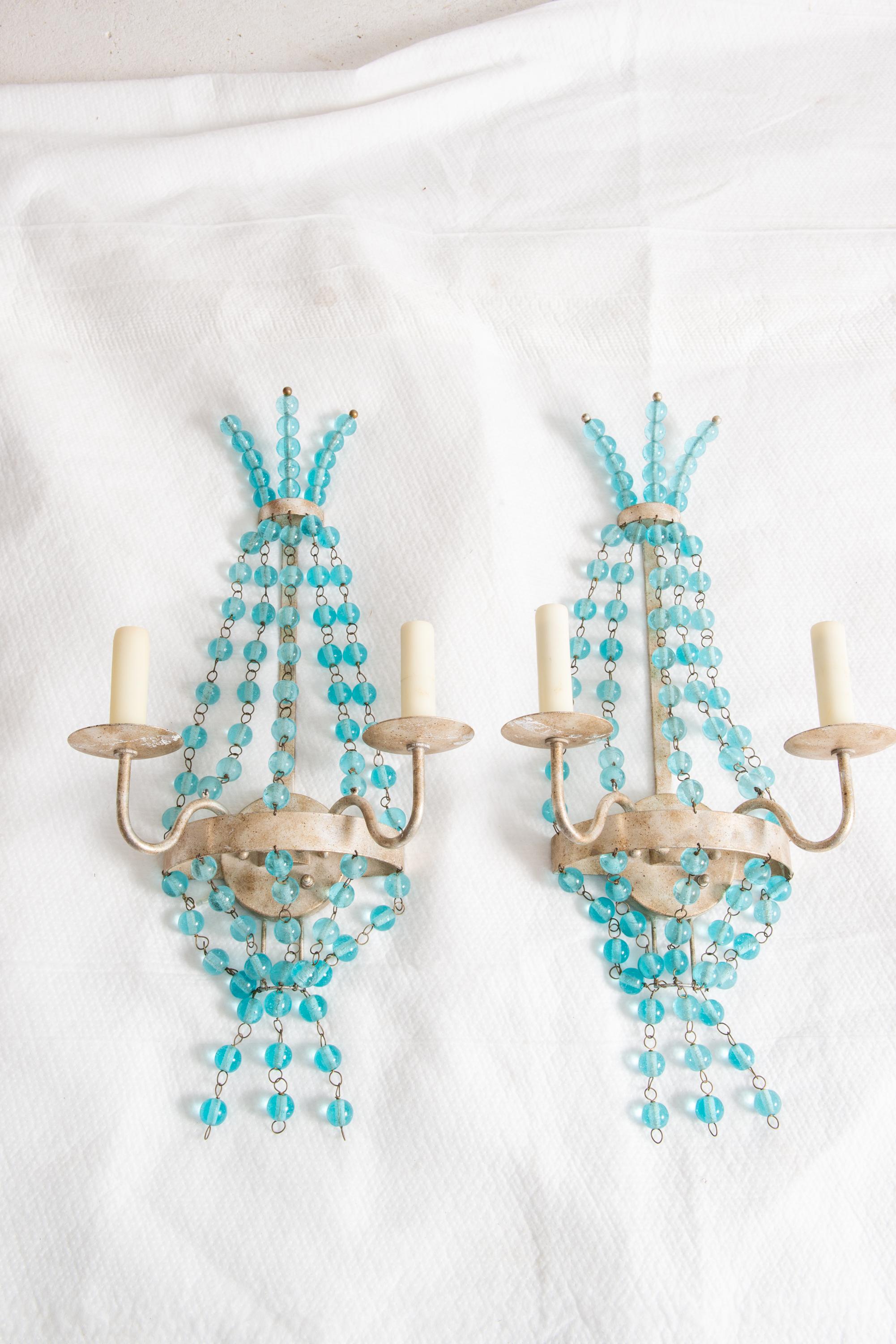 Une paire glamour d'appliques à deux bras en argenté, décorées de boules de verre aqua translucide. Il y a cinq boules de verre au-dessus et au-dessous du corps principal, ainsi que trois autres boules en haut et en bas pour terminer le look. Les