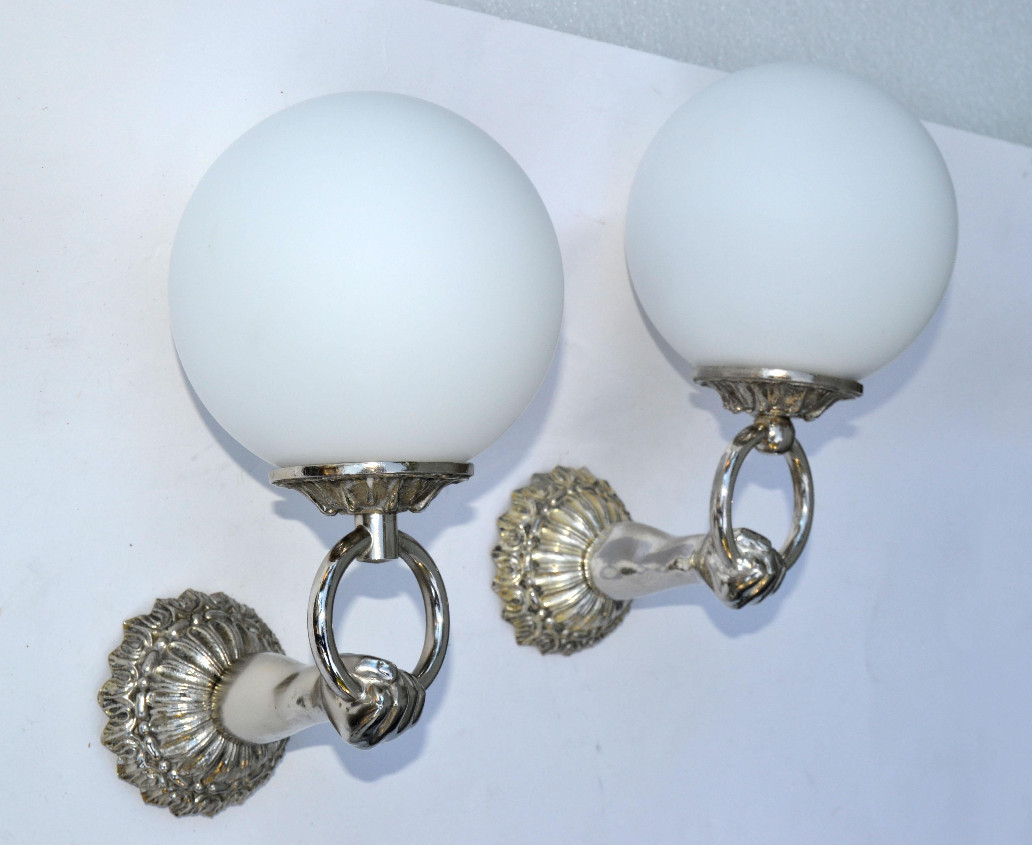 Pair of French neoclassical polished Nickel wall sconces figuring a hand holding a globe.
Each takes one light bulb with max. 60 watts.
US wired and in working condition.
Back plate measures 3.25 inches in diameter.
Please have a look on our