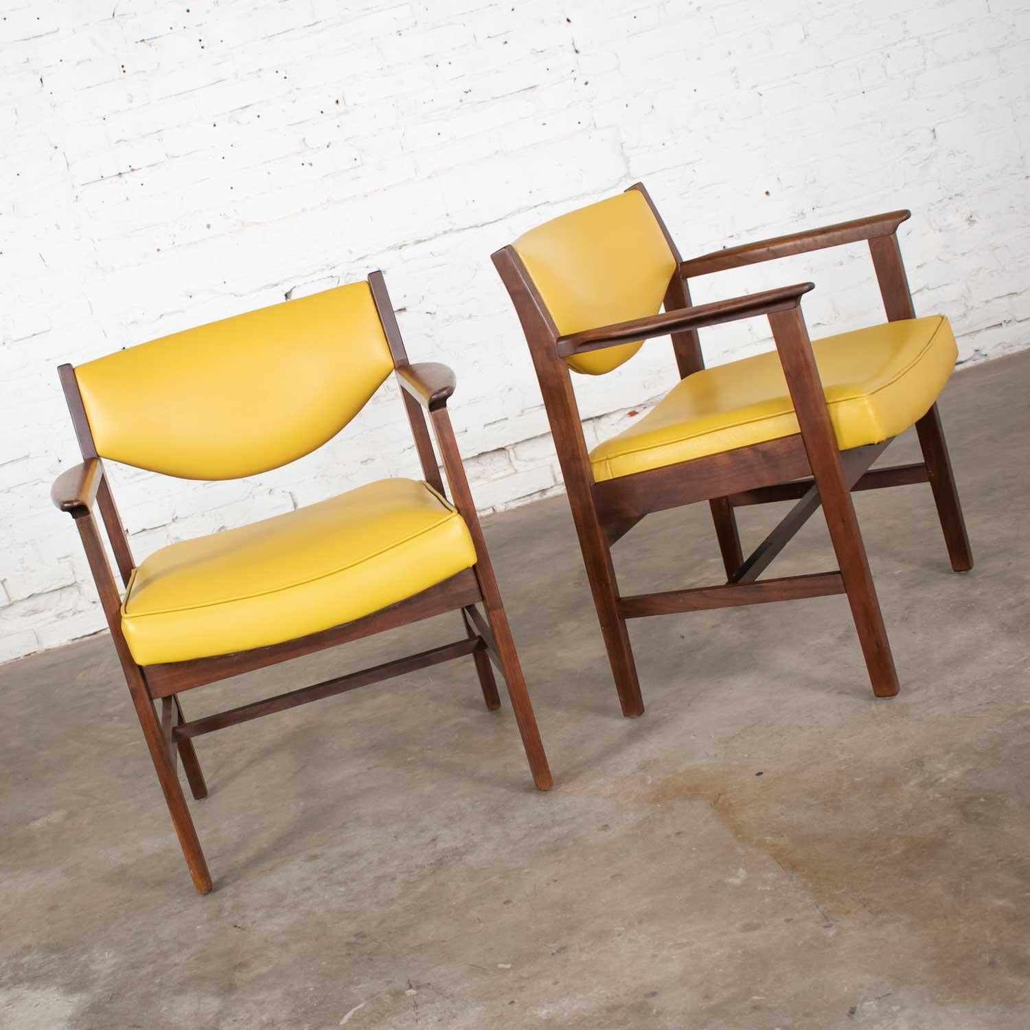 Fabolous pair of armchairs by Madison Furniture Ind upholstered in gold/yellow vinyl faux leather with walnut frame. Wonderful vintage condition. Age consistent wear with no outstanding flaws. Please see photos, circa 1960s.

Talk about comfort