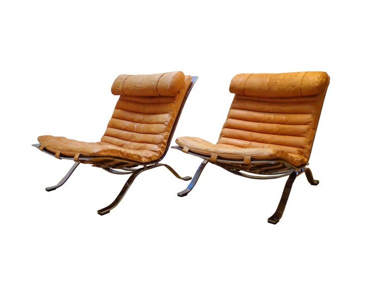 Offerd by Zitzo, Amsterdam: Pair of comfortable lounge chair designed by Arne Norell. This award winning lounge chair is made of high quality flat chrome-plated steel and original natural-cognac leather. The set is in beautiful condition with