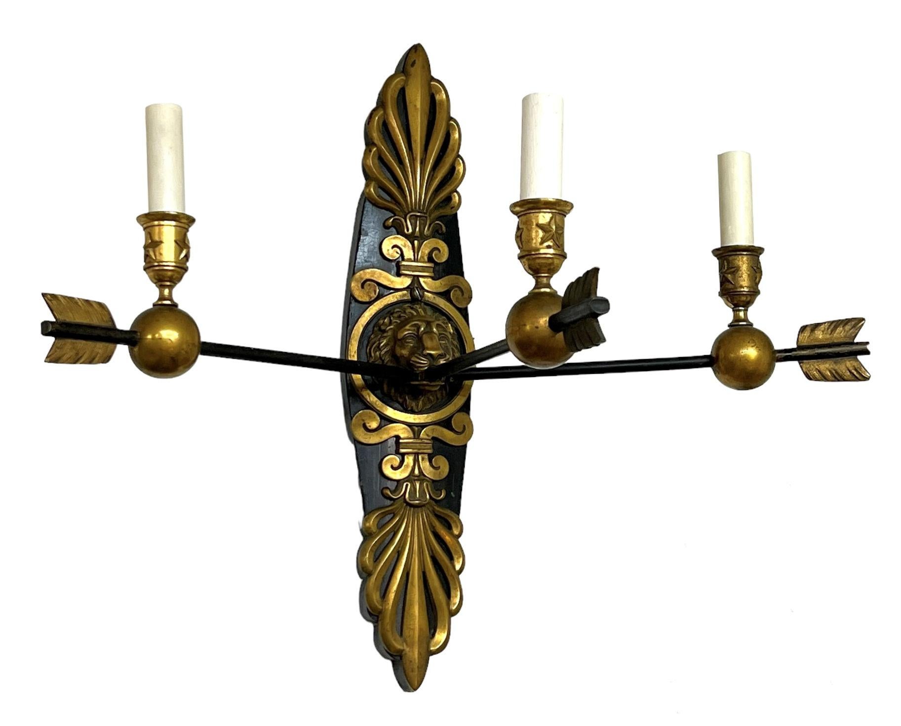Our French Empire style sconces have three arrow-form candle arms ending with candleholders with star motifs, and emanate from lion mask back plates with palmette crests that are mounted on ebonized wooden back plates. Standard size sockets with