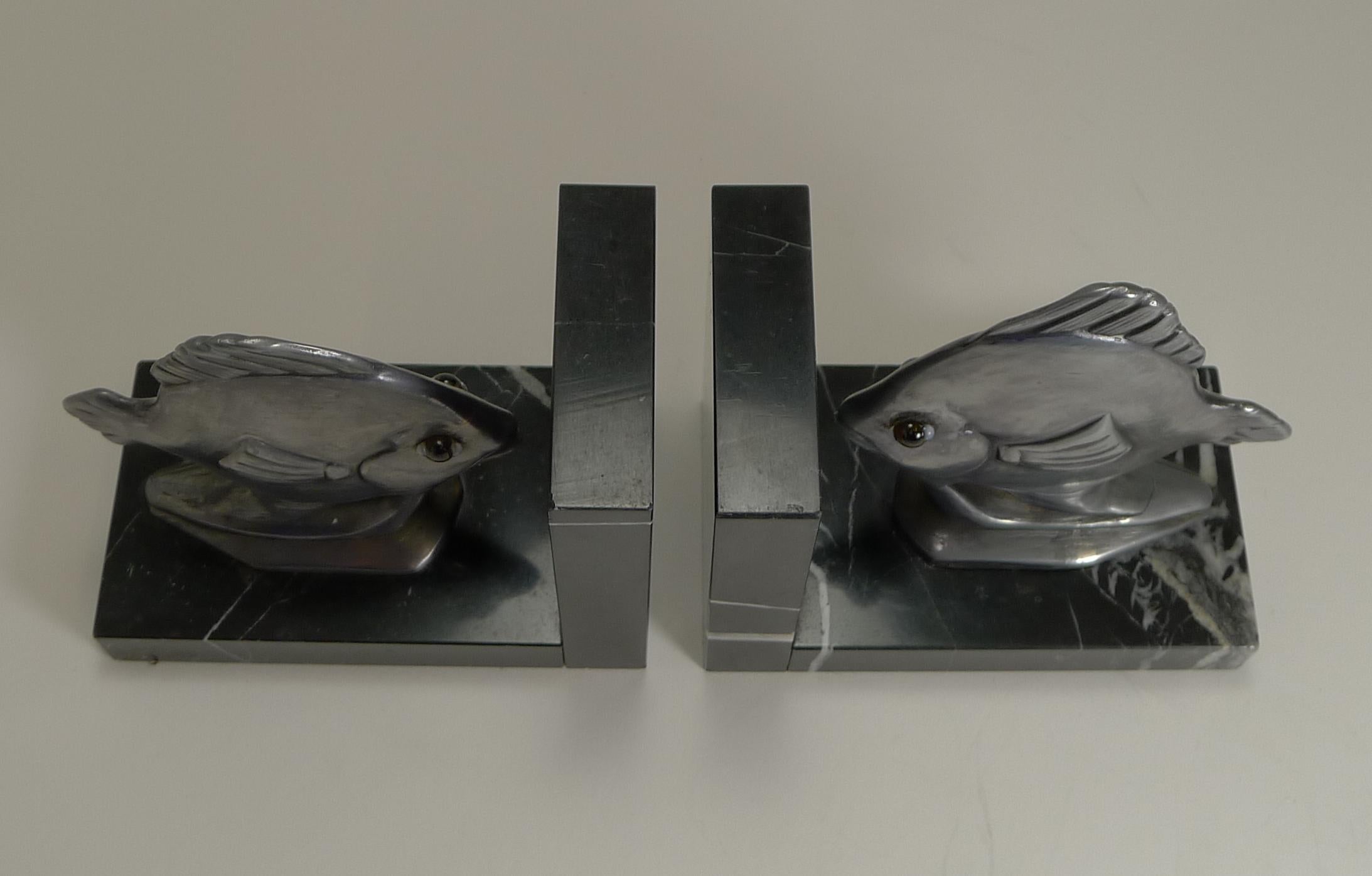 A fabulous and very stylish pair of Art Deco bookends, made from natural stone and the two fish made from a white metal possibly Pewter.

The fish both have two original glass eyes which bring this handsome pair to life.

Dating to circa 1930