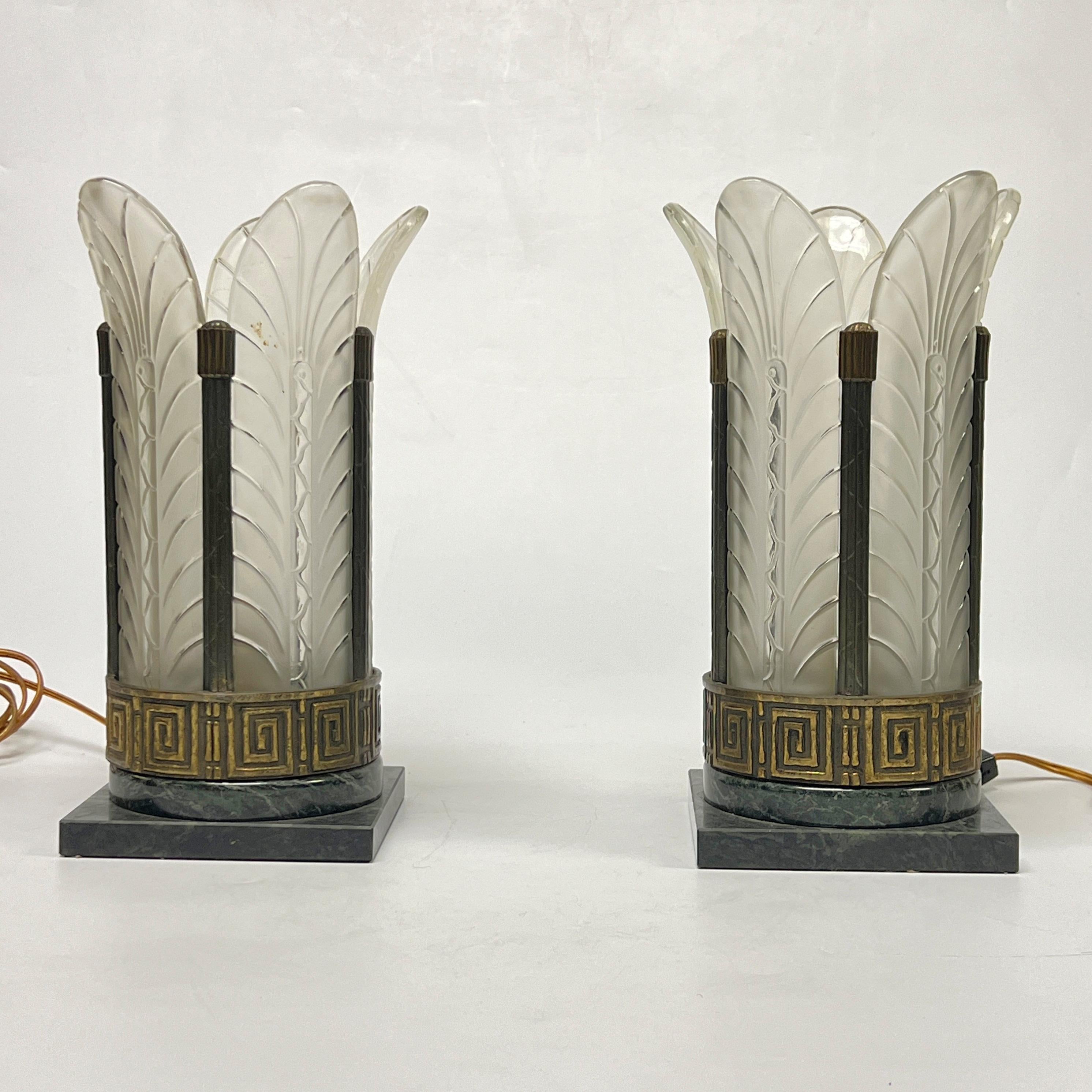 Our pair of Art Deco period lamps have variegated dark green and charcoal marble bases and circular bronze frames with Greek key motif and frosted glass panels in the form of stylized palm leaves.  Each with single standard socket and wiring and