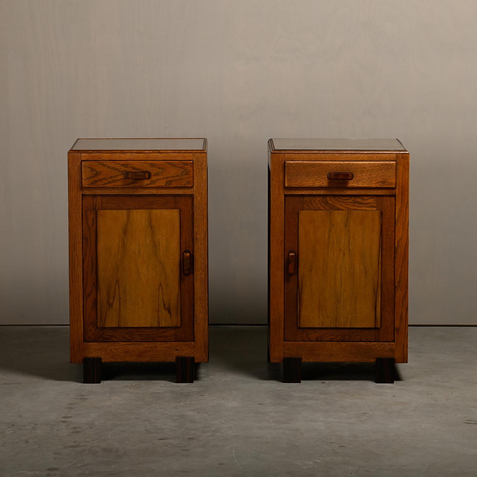 Very nice pair of Art Deco nightstands or bedside tables manufactured in the Nehterlands 1930's. Solid oak bases and drawers with bakelite handles and inlay glass tops in very good original conditon. Minor wear consistent with age and use,