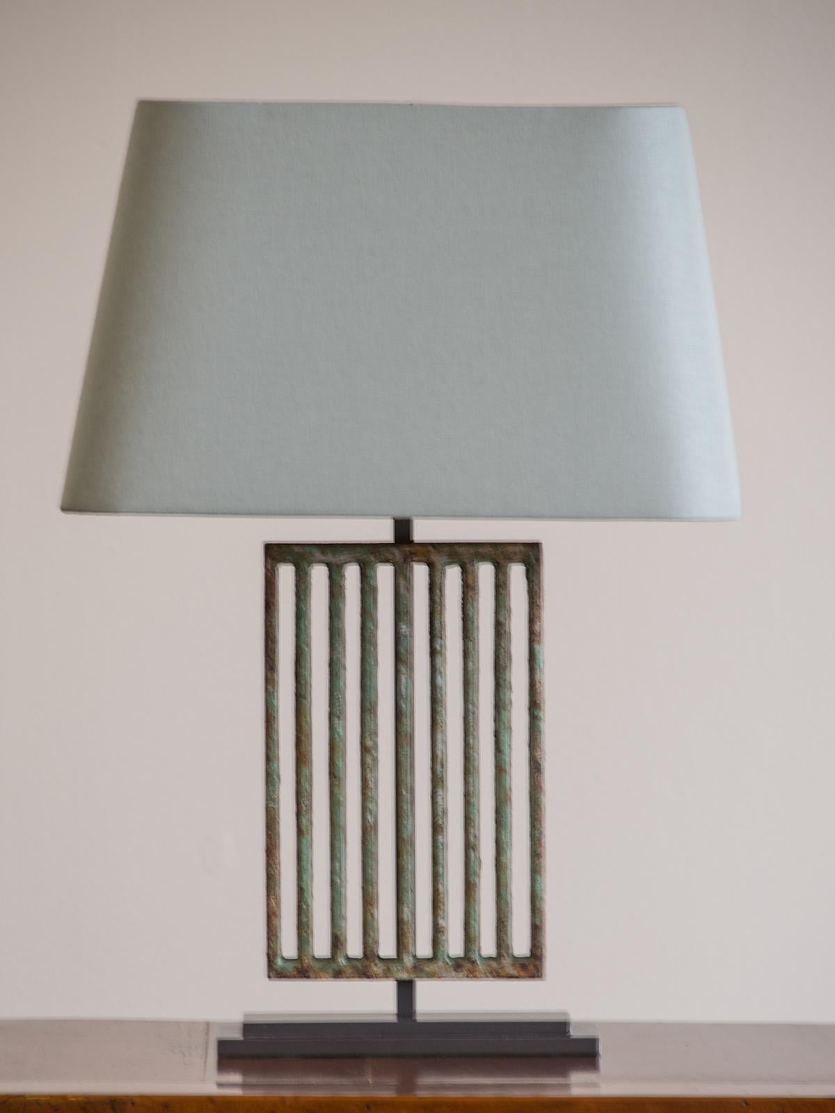 A pair of Art Deco period solid cast iron vintage French grille painted lamps from France, circa 1930 retaining their original painted finish now mounted as custom lamps on a solid steel rectangular stepped base. These lamps possess a marvellous