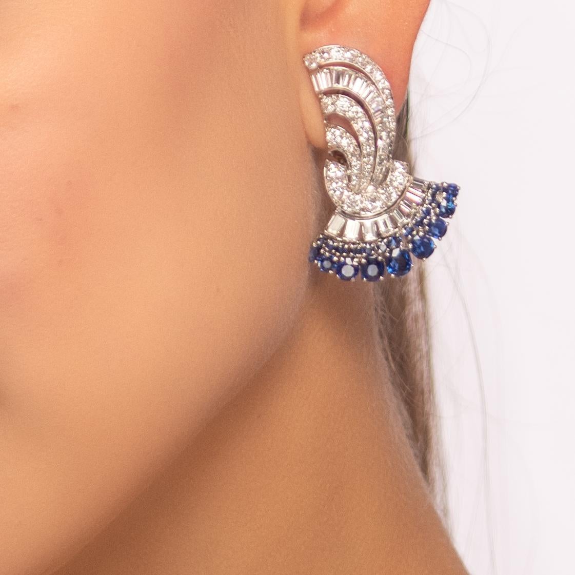 A beautiful and dramatic pair of Art Deco sapphire, diamond and platinum clip earrings. 

The earrings of elegant fan shape comprised of two curved rows of blue sapphires and a row of diamonds. Ribbons of diamonds trail and curve upwards. All