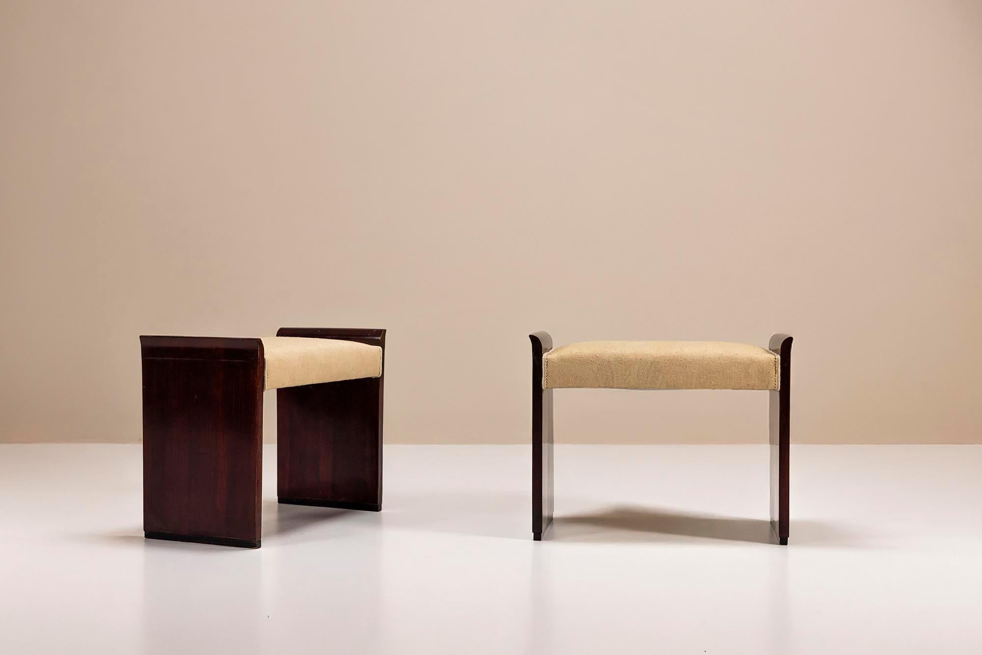 A refined balance of geometry and elegance defines this pair of Art Deco stools, likely crafted in France during the 1930s. Their clean silhouette and rich materiality evoke the era's quiet sophistication.

Design

Each stool features a solid