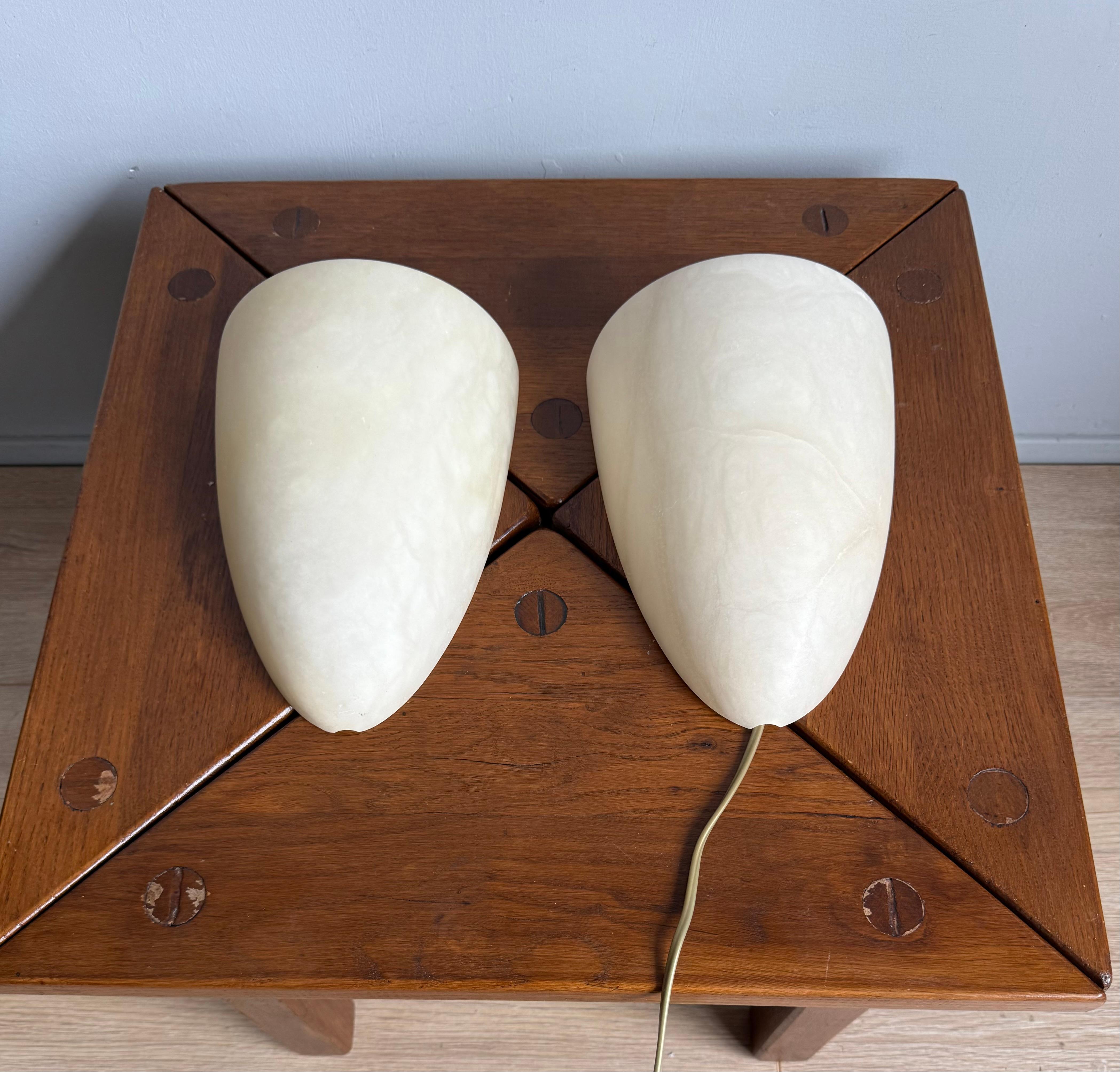 Juego de 2 apliques de pared de alabastro de mediados de siglo, artesanales y atemporales.

Este par de apliques de pared de alabastro de mediados de siglo es algo especial. Cada una está hecha a mano con auténtico alabastro, por lo que el veteado y