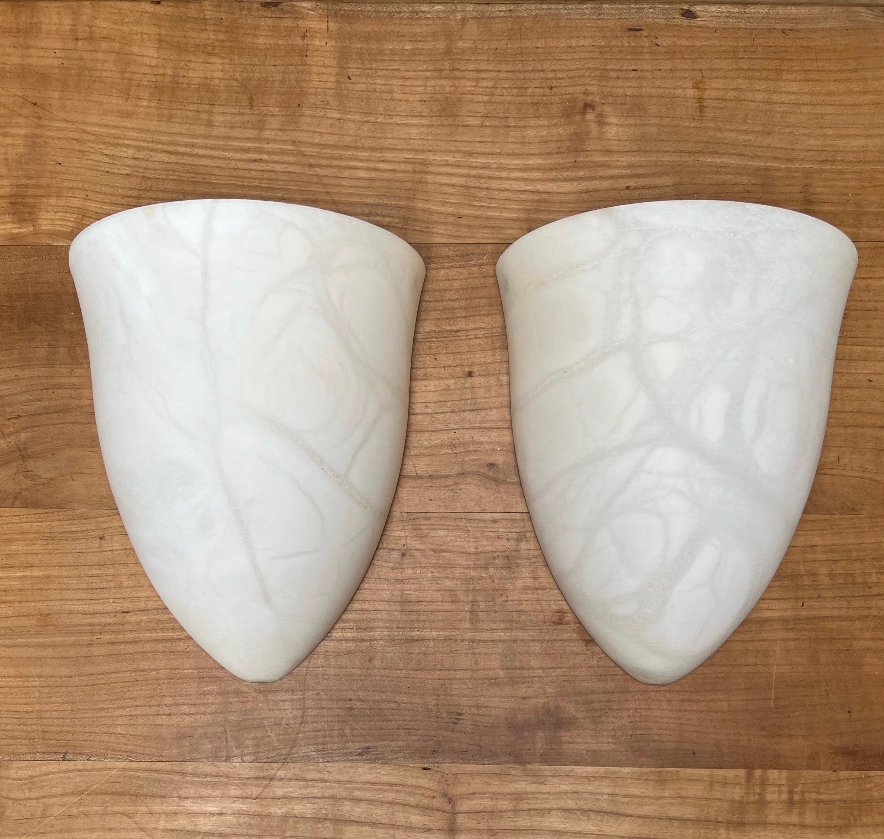 Handcrafted and very stylish pair of midcentury made alabaster wall lights.

If you are looking for a great shape and practical size pair of sconces to grace your living space then these natural mineral stone fixtures could be perfect. All