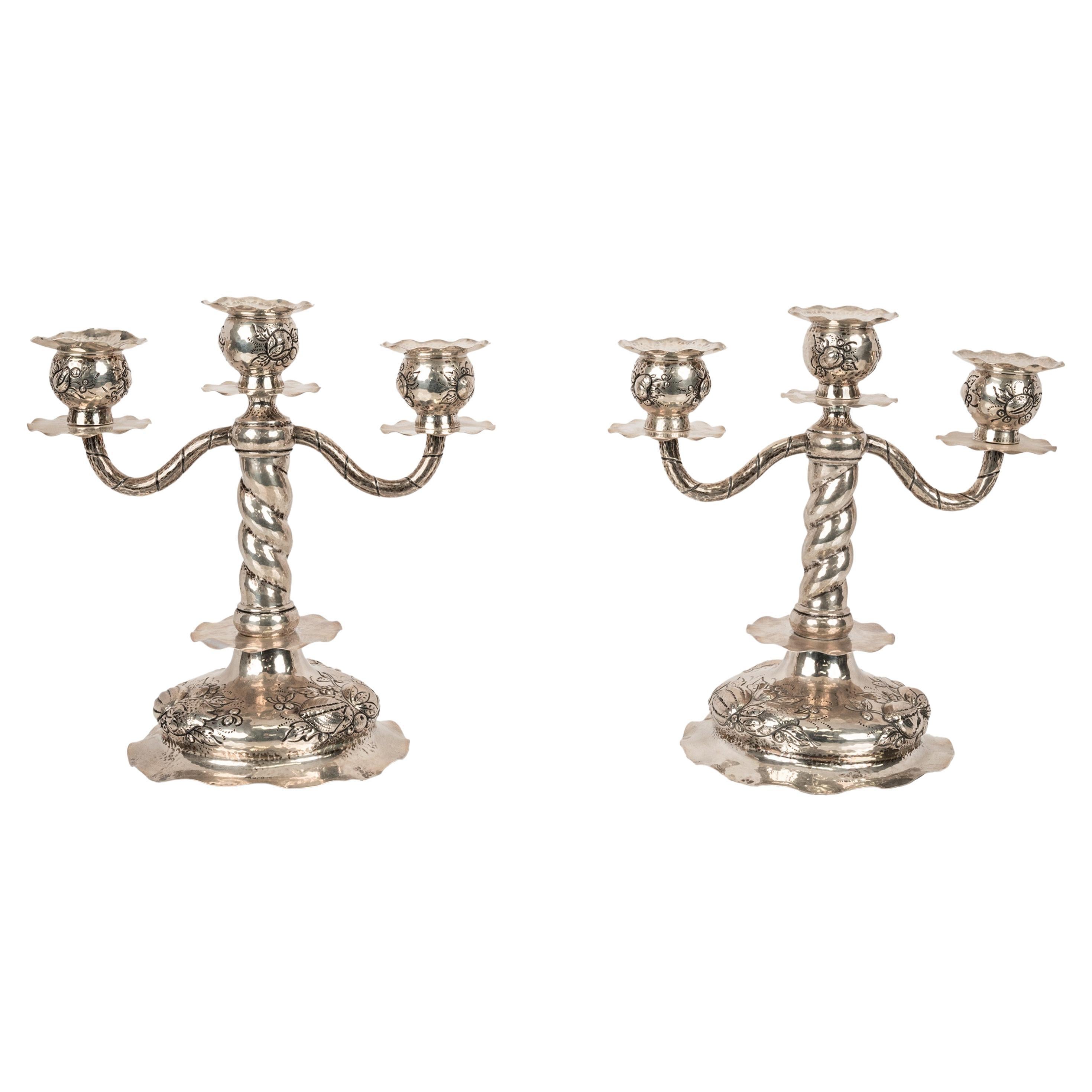 A very elegant pair of antique Art Deco silver three branch candelabrum/candlesticks, C G Hallberg, Stockholm Sweden, 1927. 
The twin arm candelabras having three candle bobeches each engraved stylized floral decoration, each with a wavy edge drip