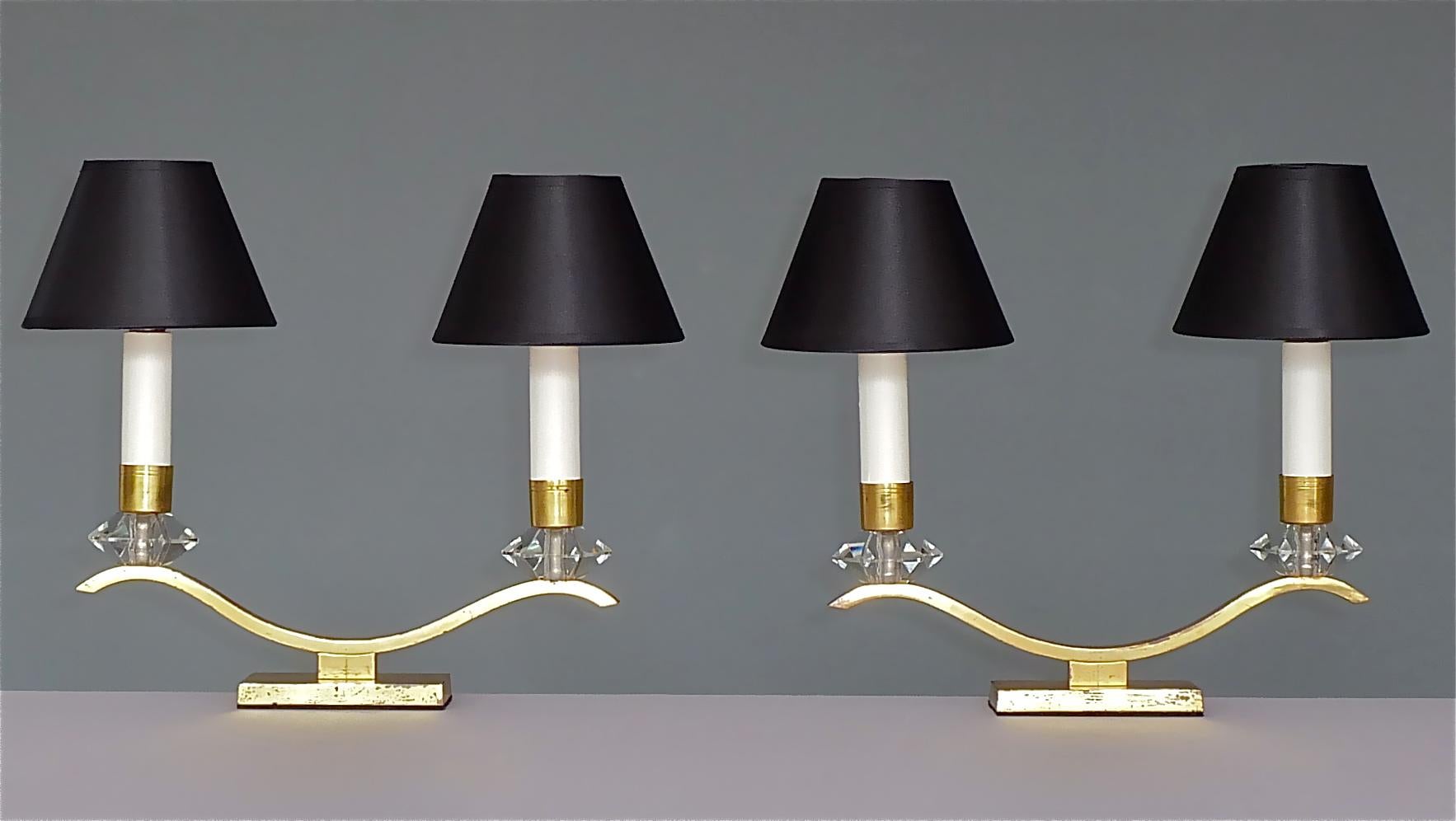 Elégante paire de lampes de table Art déco françaises dans le style de la Maison Baguès et Leleu, France, vers 1930-1940. Les lampes de table à deux bras sont en laiton avec une belle patine vieillie caractéristique, d'étonnants carbouchons /