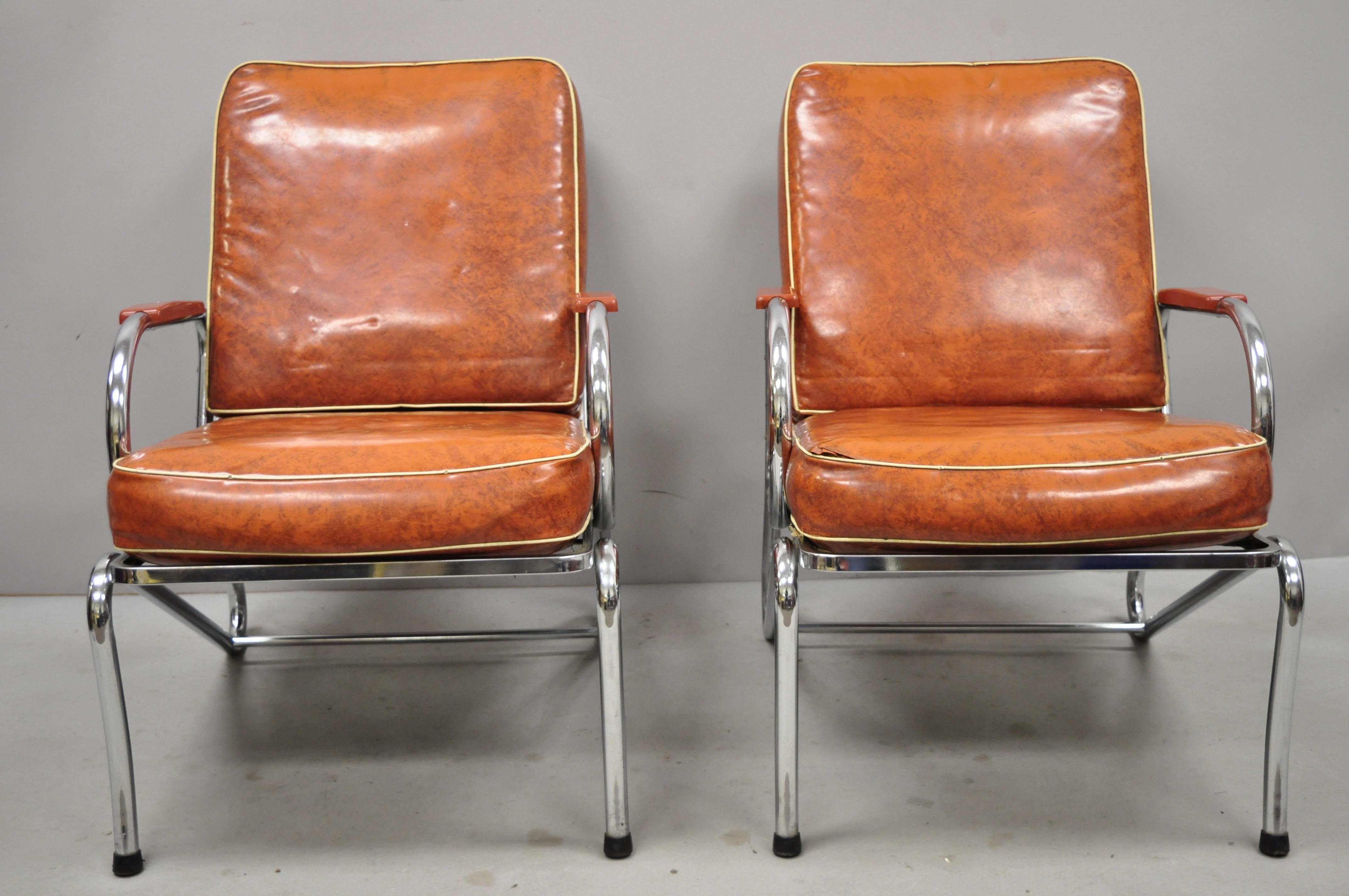 Pair of Art Deco tubular chrome red vinyl club lounge arm chairs attributed Lloyd Mfg. Listing includes original vinyl cushions, metal frames, clean modernist lines, sleek sculptural form. Maker unconfirmed, but possibly by Kem Weber for Lloyd Mfg.,
