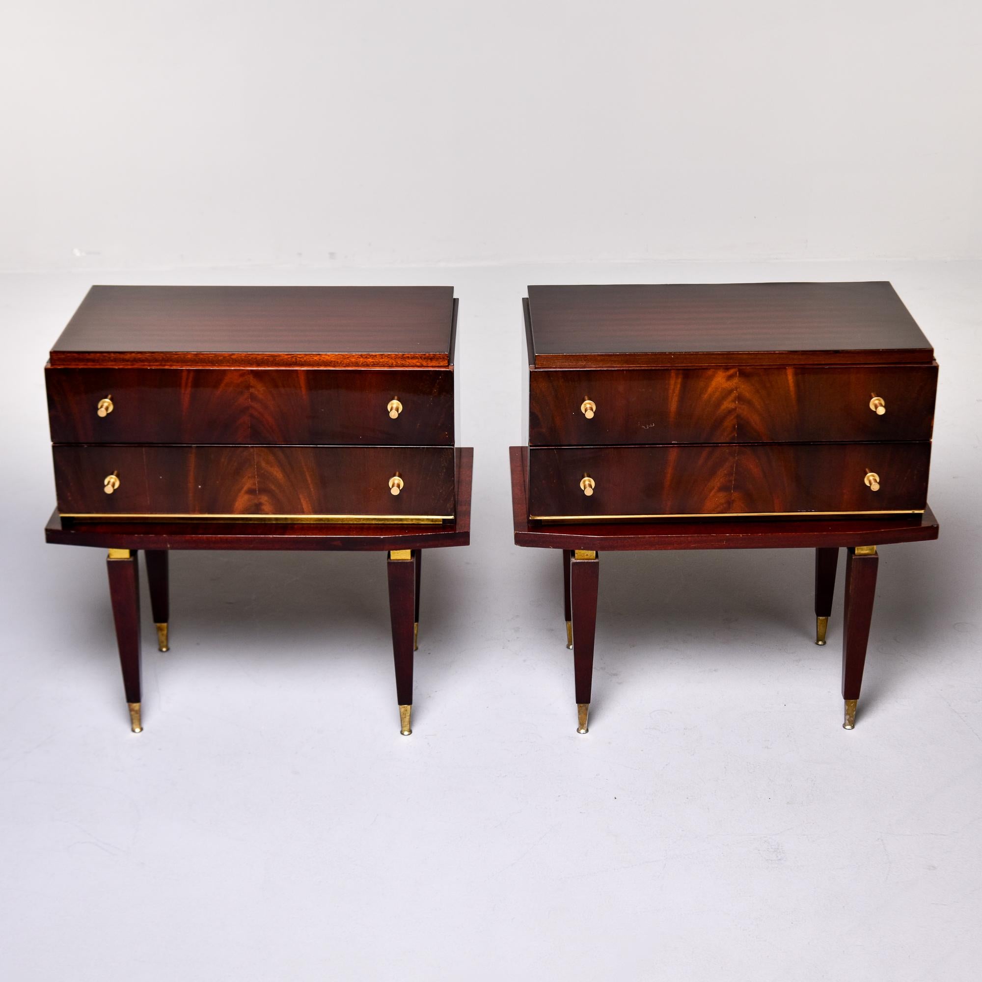 Encontradas en Francia, este par de mesillas de noche art decó / modernistas de caoba datan de finales de la década de 1940. Cada mesilla tiene dos cajones funcionales, herrajes originales de latón, patas cónicas con pies rematados en latón.