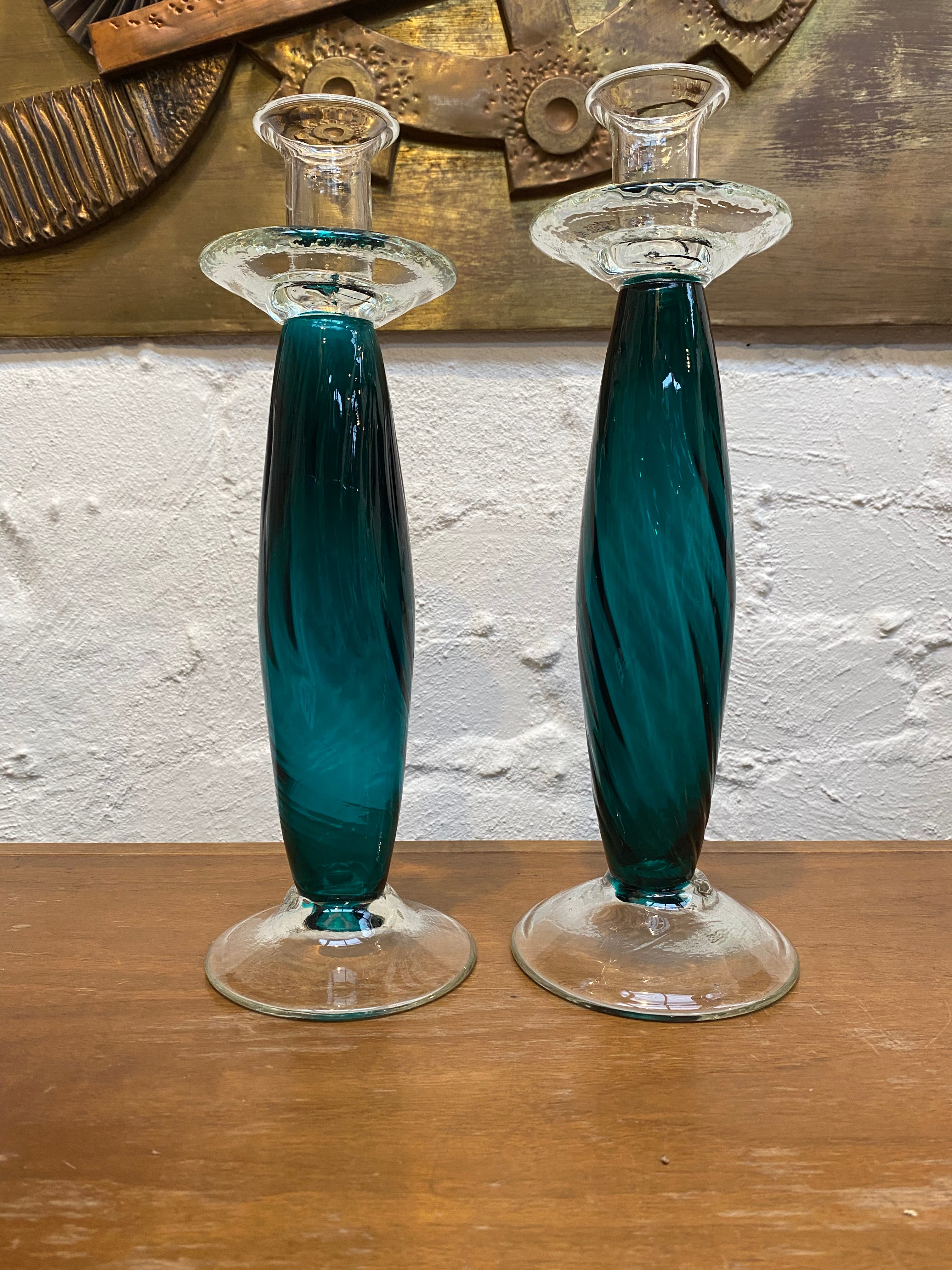 A pair of wildly romantic 1980s candlesticks in the Empoli style - bold and bountiful.  

Very pretty Teal coloured glass balloon stems with spiral pattern, finished with a clear glass candle holder and wide dish for wax. A clear glass foot or