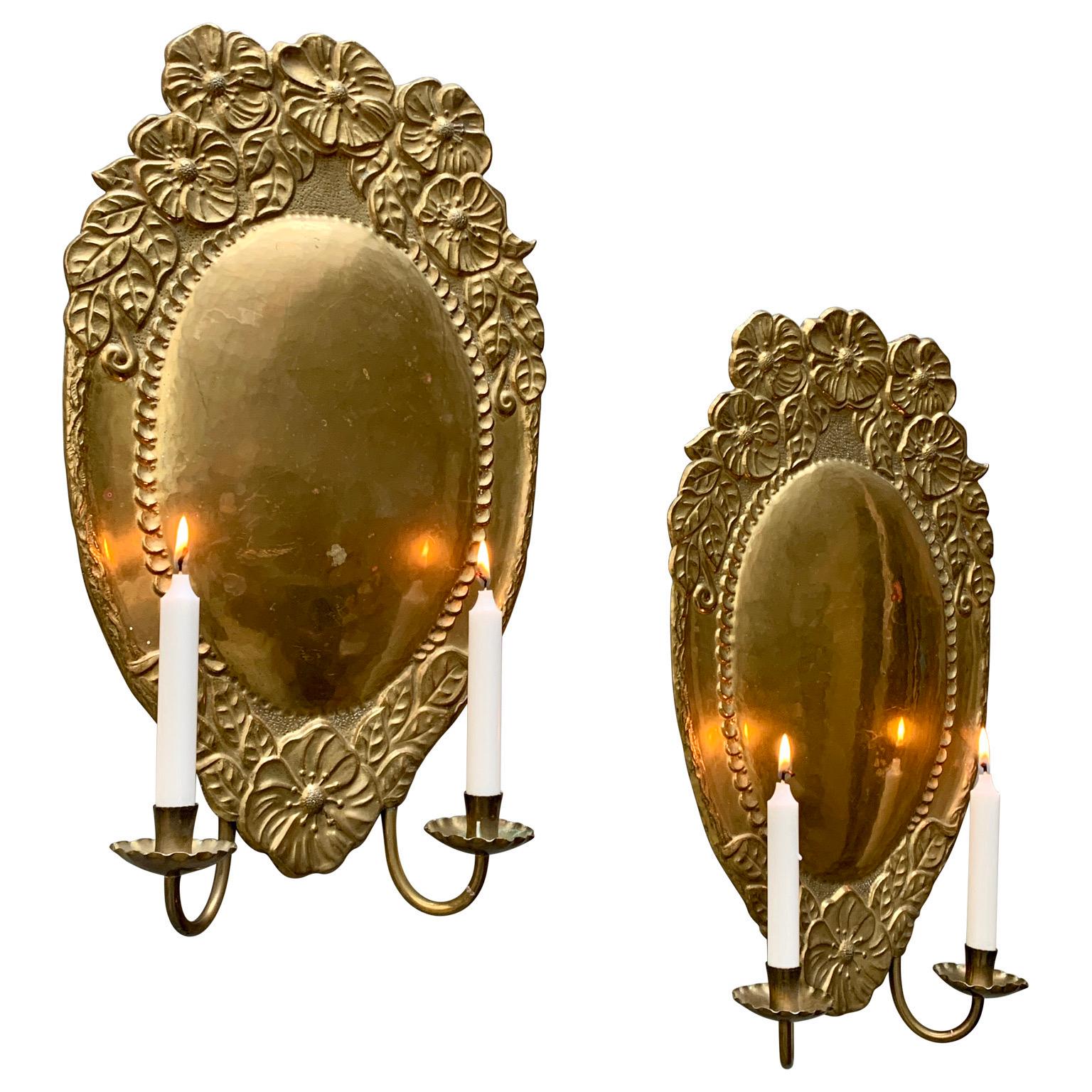 Pair of Liberty style wall sconces in brass with double candle holders on each sconce.
The rich flower decoration is typical for this period of the early 20th Century in Europe, were it has been called in different manner, like 