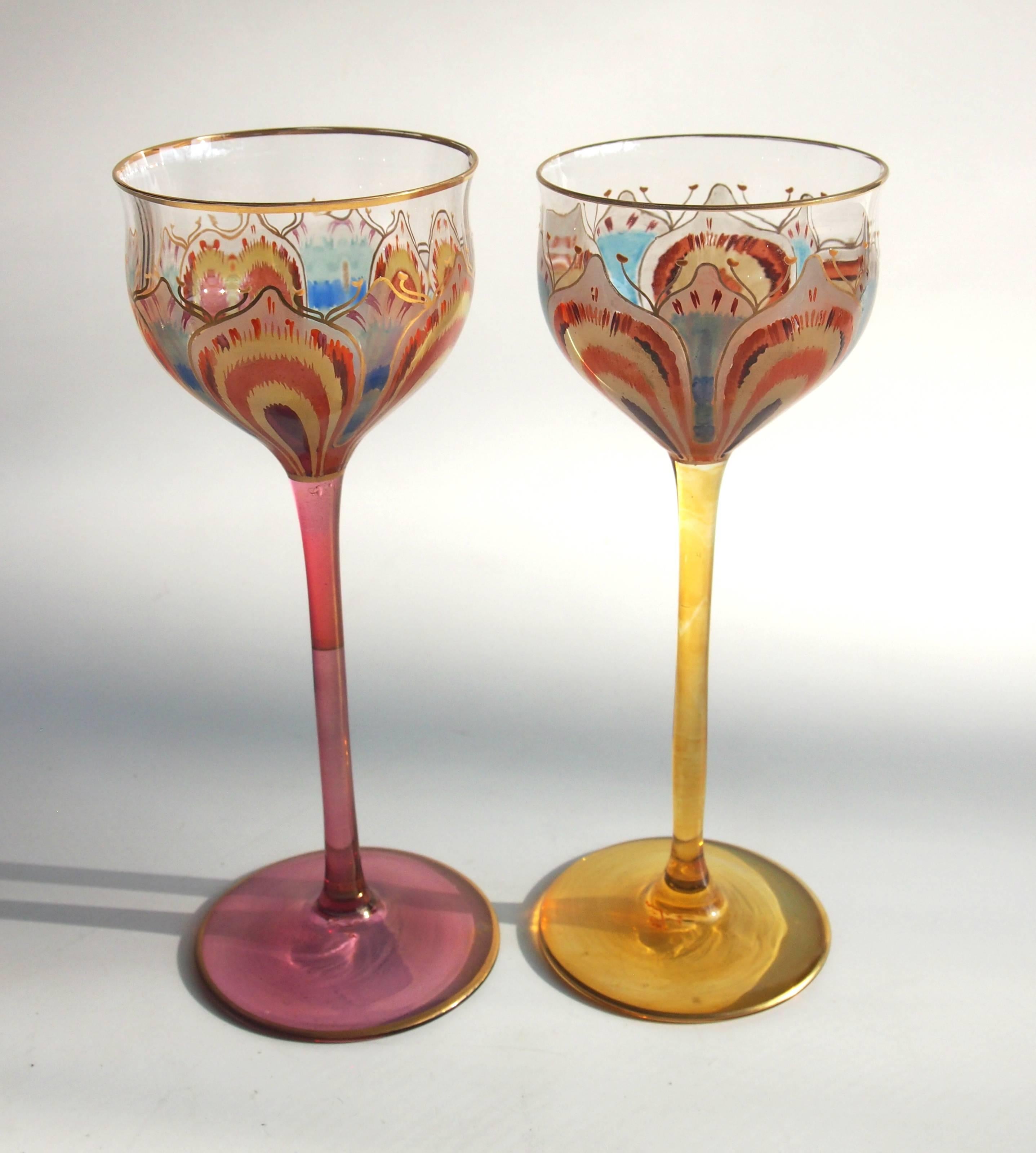 Superb pair of Art Nouveau gilded and enameled, almost psychedelic, Meyr's Neffe 'Flower' glasses. One with a yellow stem and one with a pink stem. They are enameled with an open flower around the bowl so only when you drink from them do you get the