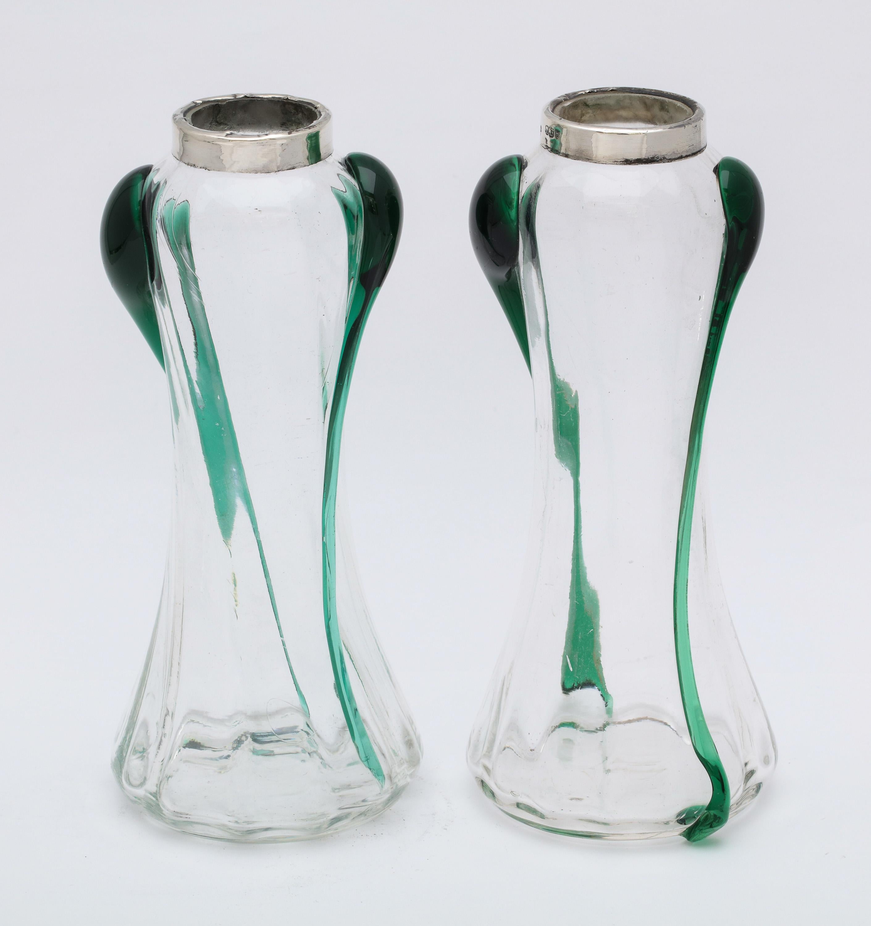 Pair of unusual, Art Nouveau, sterling silver-mounted hand blown dark green and clear glass bud vases, London, 1904, A. Bromet and Co. - makers. Each vase stands 6 1/2 inches high x 2 3/4 inches diameter (at widest point) x 1 1/2 inches diameter