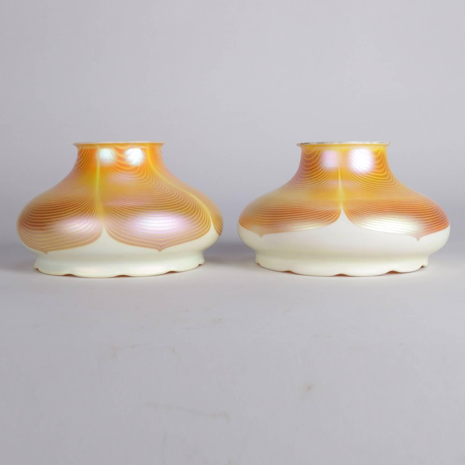 Pair of Arts & Crafts oversized Quezal art glass lamp shades feature gold aurene and calcite pulled feather design, floral form with ruffled rims, circa 1920

Measure: 5