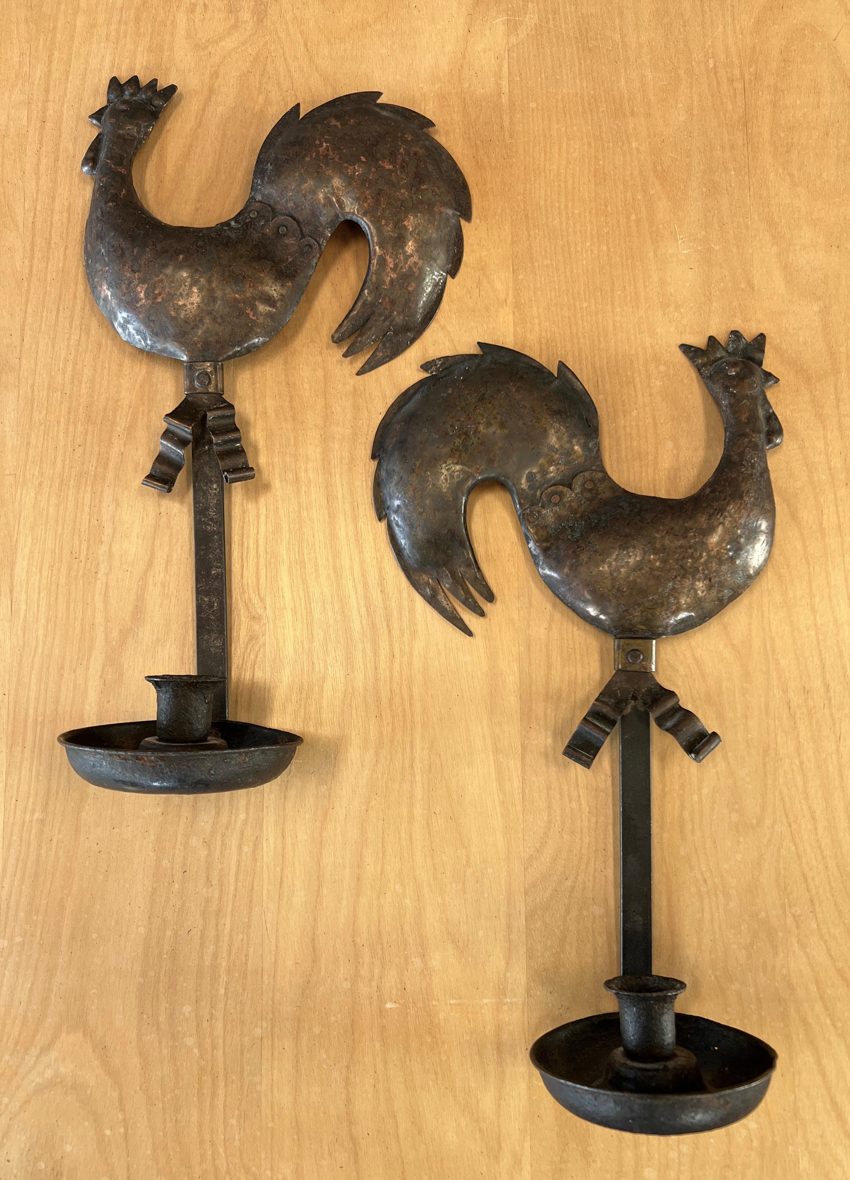 Offered here are a pair of handsome Arts and Crafts Gallic Rooster sconces.
They're both made out of hammered Copper. 
Candle holder with a flat hook shape bar goes around the holder and then up to hold the rooster. Right below
the roosters have