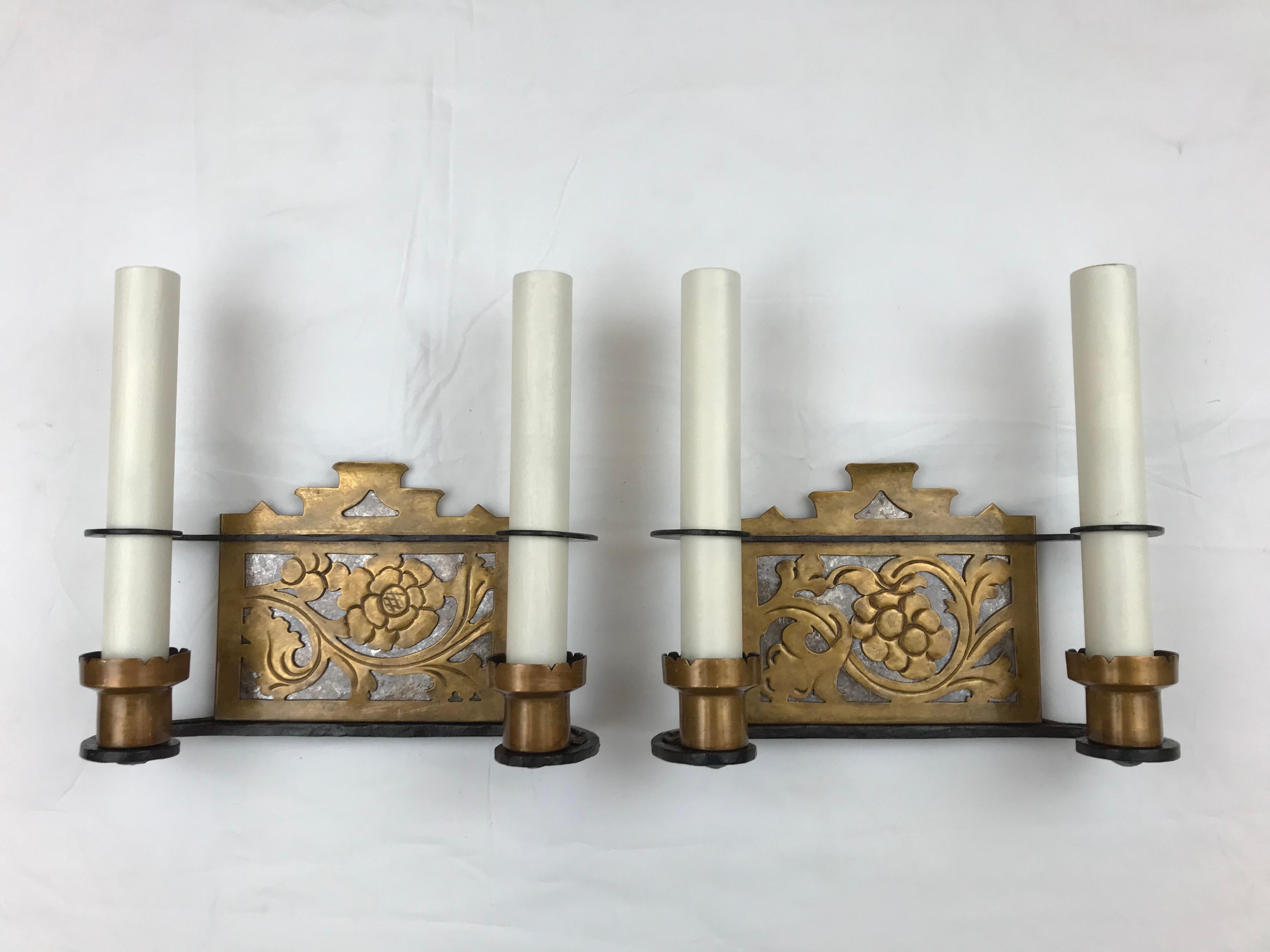This high style pair of Arts and Crafts sconces are hand made of wrought iron and bronze with mica backs.  They are attributed to Oscar Bach, the renown Arts and Crafts designer and manufacturer of metalware.