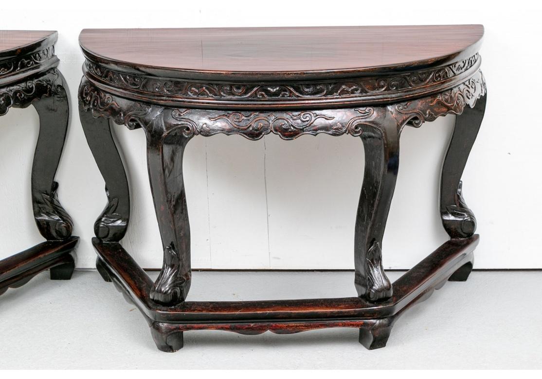 Pair of Demi-Lune Consoles made with dowels to be joined as a Hexagonal Base Center Table if desired. The wood tops over dark stained and carved bases in a sophisticated antiqued Lacquer finish. Raised foliate scrolled friezes, the lower one