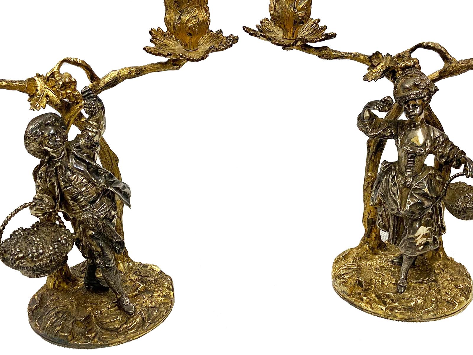 A fine quality pair of solid silver and gilt candelabras, by Aspreys of London, 20th century, depicting chanting lovers picking fruit under branches.
Weighing 88oz (2737 grams). Measures: 8.5” (22 cm).